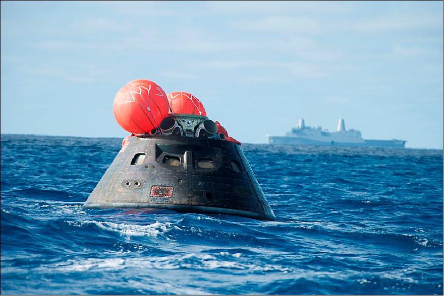Figure 23: Orion crew module after splash down in the Pacific Ocean with the Crew Module Uprighting System bags deployed and the USS Anchorage in the background that concludes its first test flight on the EFT-1 mission on Dec. 5, 2014 (image credit: U.S. Navy)