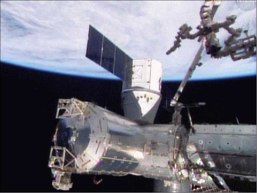 Figure 10: The Canadarm2 with Dextre in its grasp is in the middle of removing external cargo from the SpaceX Dragon commercial cargo craft image credit: NASA TV)