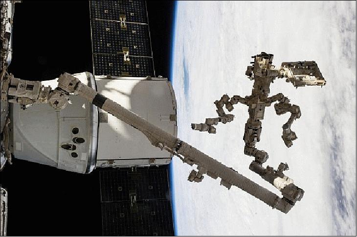 Figure 8: Backdropped against a cloudy portion of Earth, Canada's Dextre robotic "handyman" and Canadarm2 dig out the trunk of SpaceX's Dragon cargo vessel docked to the ISS after completing a task some 365 km above the home planet (image credit: NASA TV)