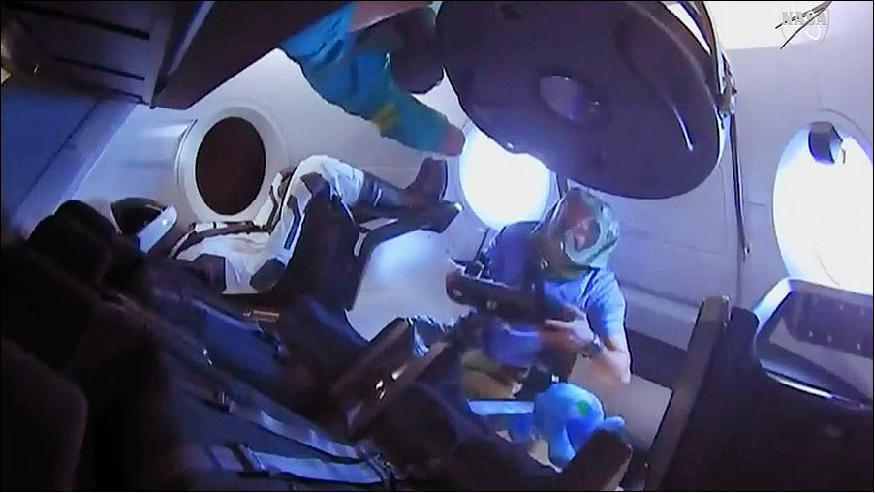 Figure 6: Expedition 58 crew members enter the SpaceX Crew Dragon for the first time. They are wearing protective gear to avoid breathing particulate matter that may shaken loose during launch (image credit: NASA)
