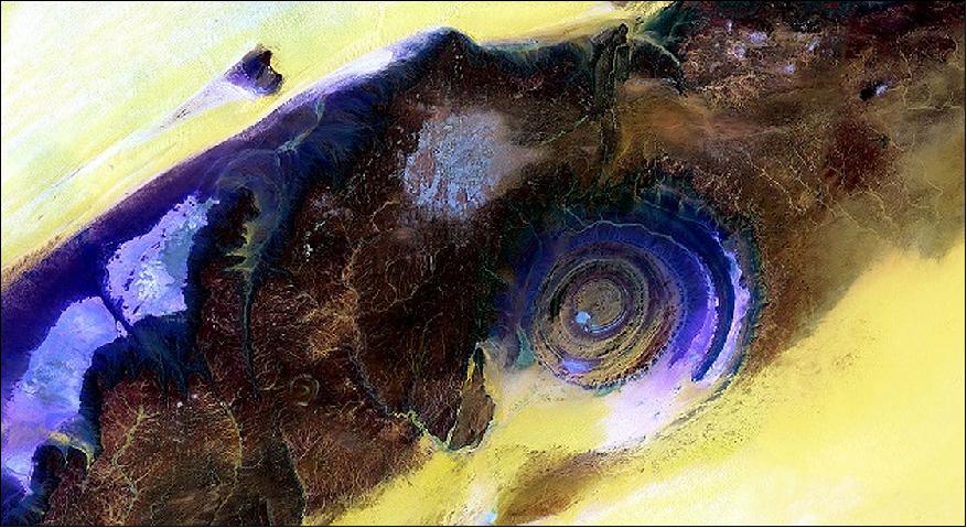 Figure 87: Eye of the Sahara, Mauritania, acquired on June 28 and July 5, 2015 (Lat: 20.983º, Long: -11.459º): This Landsat mosaic of four different scenes shows the geologic feature in false color. By blending visible and infrared wavelengths (bands), scientists can enhance the visibility of the various rock layers in contrast to the surrounding sand (yellow to white), image credit: EROS Data Center, USGS
