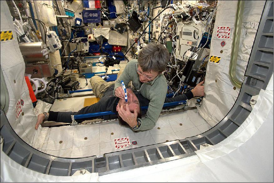 Figure 51: NASA astronaut Peggy Whitson measures pressure in ESA astronaut Thomas Pesquet's eyes for the Fluid Shift experiment. Weightlessness tends to weaken an astronaut's vision. Monitoring why and to what degree can lead to preventive measures. Experiments like this are one of many astronauts conduct during their missions on the ISS (image credit: ESA/NASA) 50)