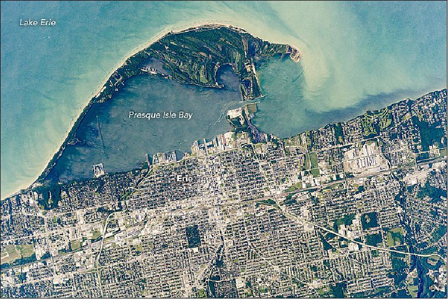 Figure 1: The curved peninsula of Presque Isle State Park juts into the Great Lake, while the city in the lower part of the image is the deep-water port of Erie, Pennsylvania. This astronaut photograph ISS052-E-6364 was acquired on June 21, 2017, with a Nikon D4 digital camera using an 1150 mm lens, and is provided by the ISS Crew Earth Observations Facility and the Earth Science and Remote Sensing Unit, Johnson Space Center. The image was taken by a member of the Expedition 52 crew)