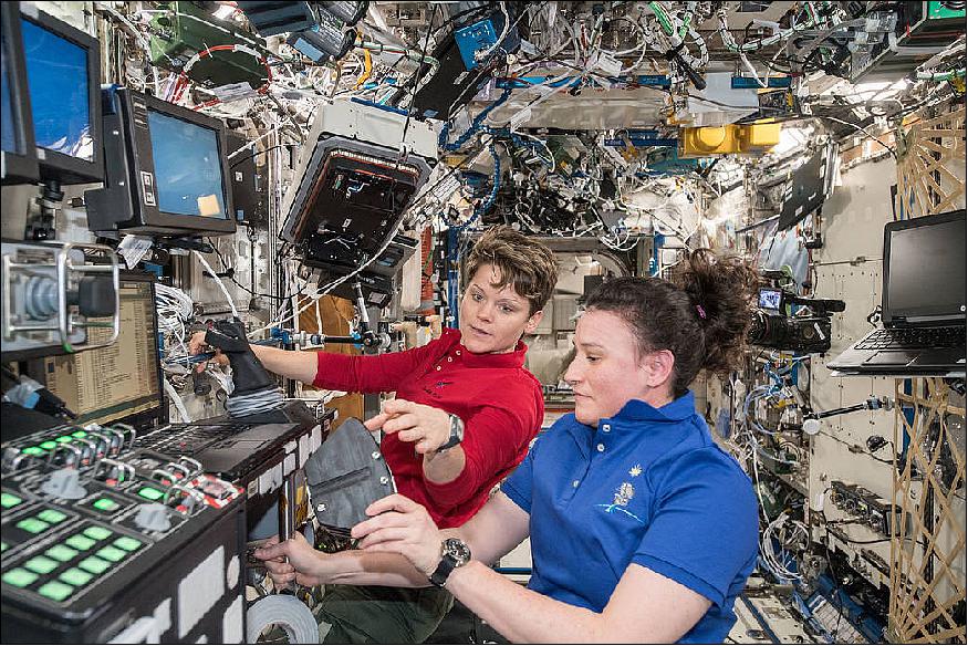 Figure 12: NASA astronauts Anne McClain (background) and Serena Auñón-Chancellor are pictured inside the U.S. Destiny laboratory module aboard the International Space Station. McClain watched as Auñón-Chancellor trains on the robotics workstation ahead of the rendezvous and capture of the SpaceX Dragon cargo craft on Dec. 8, 2018 (image credit: NASA)