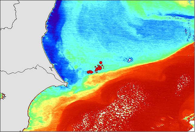 Figure 4: Boso Peninsula SST (Sea Surface Temperature) and the seine fishing ground as observed by Shikisai. In this image, the coolest waters appear in blue, and the warmest temperatures appear in red. Red circles are fishing spots for Japanese pilchard (Sardinops melanostictus). A band of waters at high temperature (in red) along the Japan current lies on the south of the fishing ground. Warm water (orange to green) veers north, countercurrent, off from the Japan current. Cold water (blue) is distributed along the Kashima coast. This suggests fishing grounds are formed where warm waters move north (image credit: JAXA)