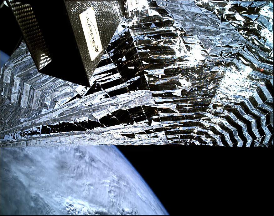Figure 9: Image acquired by the inspection camera on board TechDemoSat-1 showing the Icarus-1 sail deployed with a view of Earth's beyond. The equipment top left is the satellite's Antenna Pointing Mechanism (image credit SSTL)