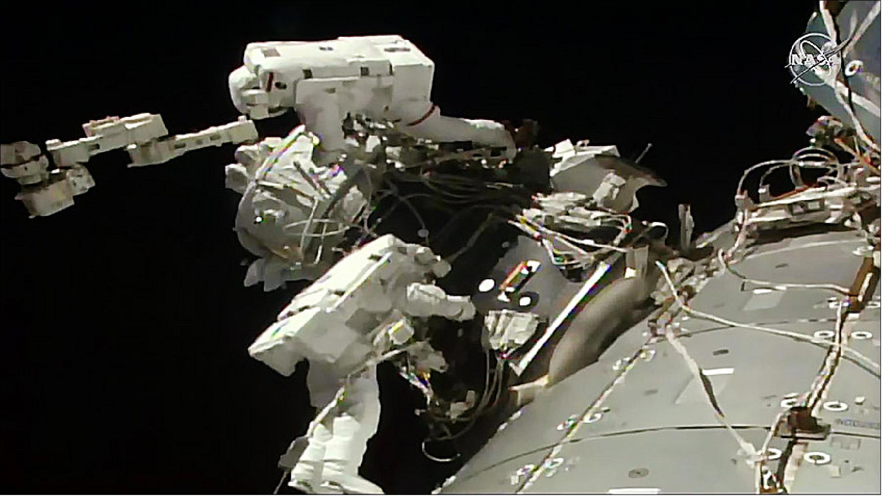 Figure 60: Spacewalkers Nick Hague (top) and Andrew Morgan install the International Docking Adapter (IDA-3) to the Pressurized Mating Adapter on top of the station’s Harmony module (image credit: NASA TV)