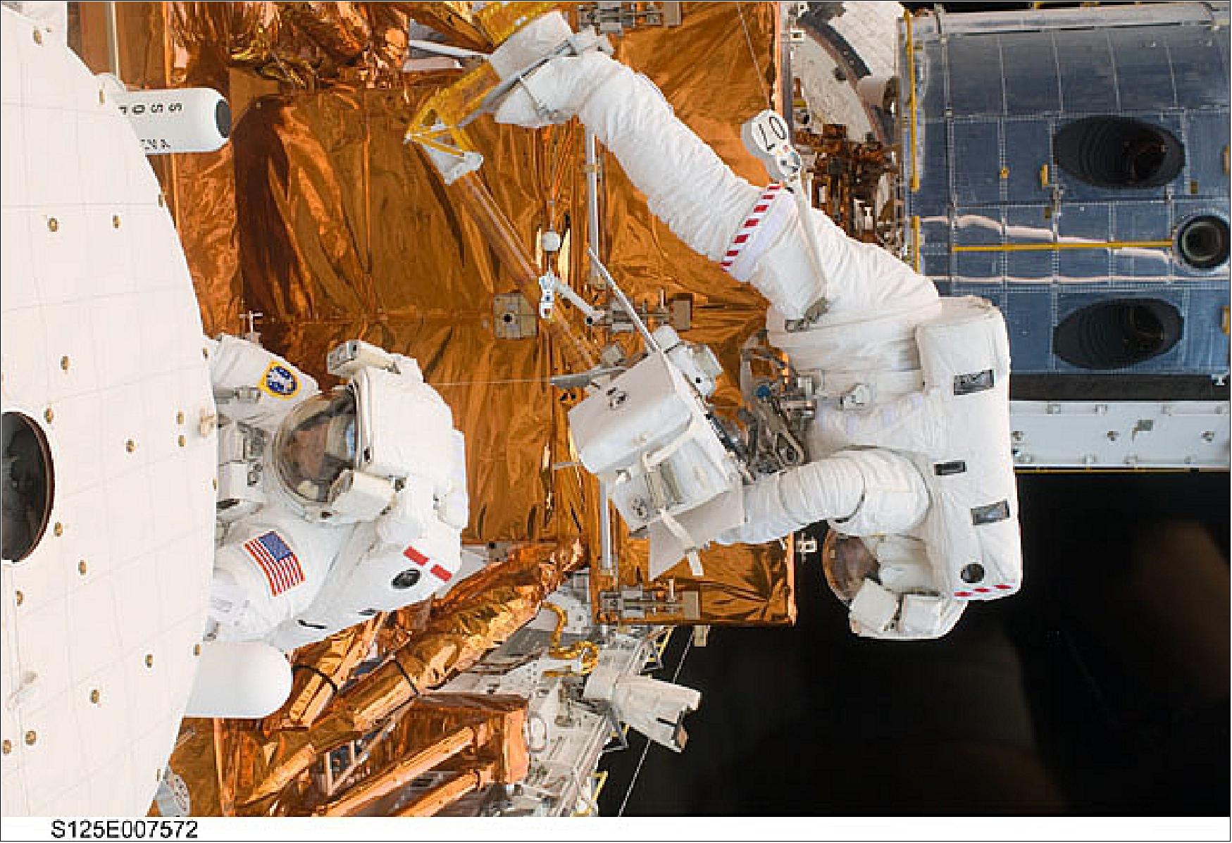 Figure 68: Astronaut Michael Good works with the Hubble Space Telescope in the cargo bay of the Earth-orbiting Space Shuttle Atlantis along with Mike Massimino (image credit: NASA)