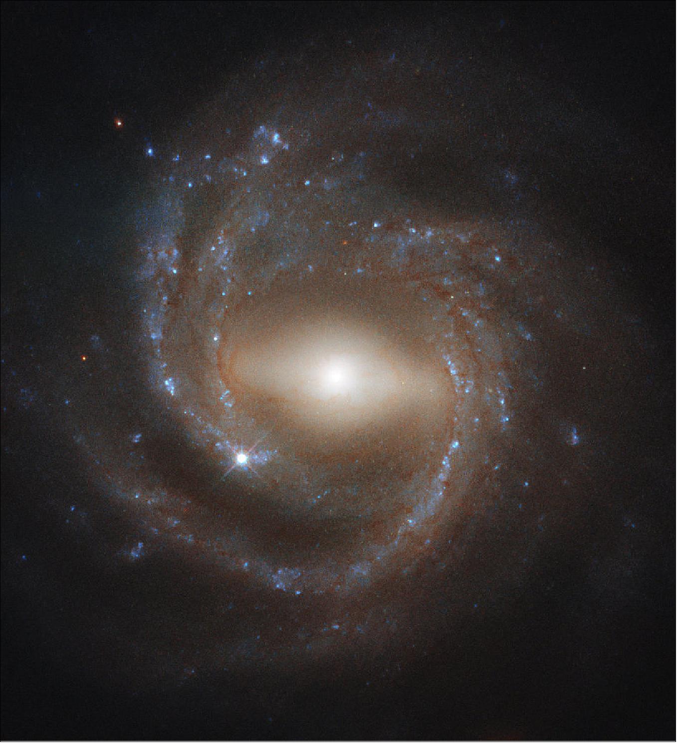 Figure 45: Our galaxy, the Milky Way, is thought to be a barred spiral like NGC 7773. Shown here, NGC 7773 is a beautiful example of a barred spiral galaxy in the constellation Pegasus. A luminous bar-shaped structure cuts prominently through the galaxy's bright core, extending to the inner boundary of NGC 7773's sweeping, pinwheel-like spiral arms. Astronomers think that these bar structures emerge later in the lifetime of a galaxy, as star-forming material makes its way towards the galactic center — younger spirals do not feature barred structures as often as older spirals do, suggesting that bars are a sign of galactic maturity. They are also thought to act as stellar nurseries, as they gleam brightly with copious numbers of youthful stars (image credit: ESA/Hubble & NASA, J. Walsh)