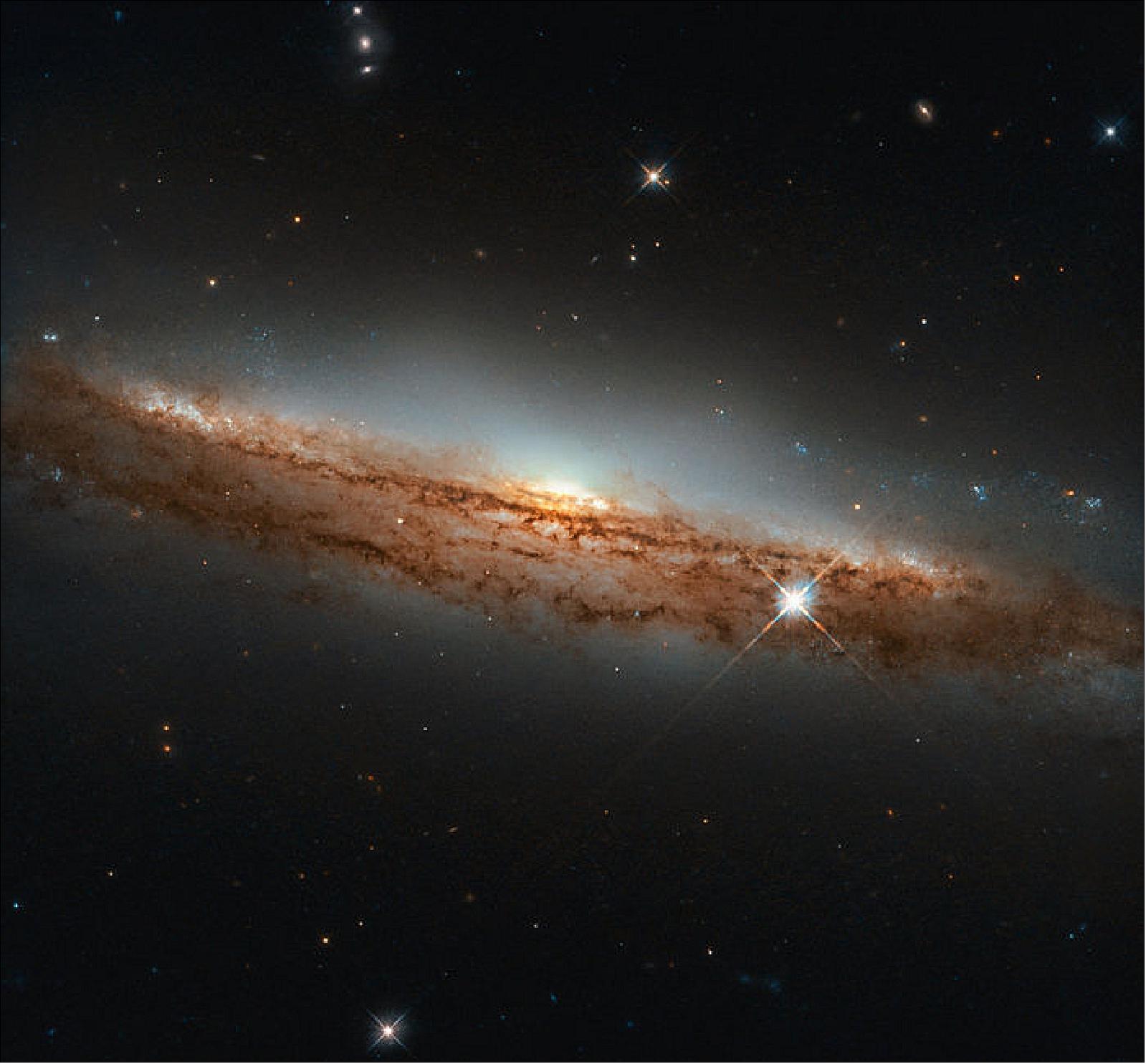 Figure 20: Seeing a spiral almost in profile, as Hubble has here, can provide a vivid sense of its three-dimensional shape. Through most of their expanse, spiral galaxies are shaped like a thin pancake. At their cores, though, they have bright, spherical, star-filled bulges that extend above and below this disc, giving these galaxies a shape somewhat like that of a flying saucer when they are seen edge-on (image credit: ESA/Hubble & NASA, D. Rosario; CC BY 4.0)