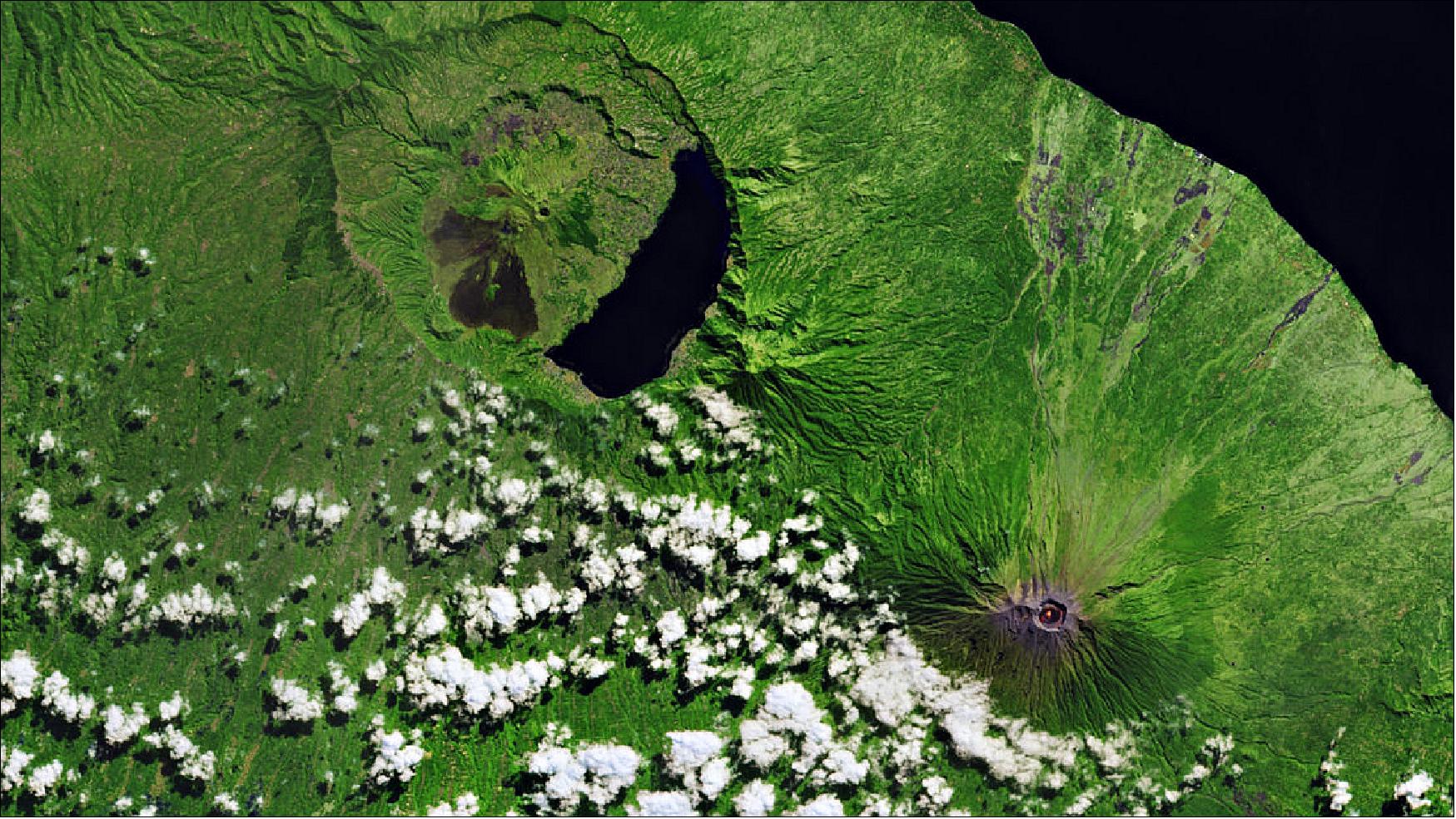 Figure 34: This image of Mount Agung on the Indonesian island of Bali was captured on 2 July 2018 by the Copernicus Sentinel-2 mission (the image was released on 22 February 2019, offering a ‘camera-like’ view of the Agung and Batur volcanoes). After being dormant for 50 years, Mount Agung erupted in November 2017. It has continued to erupt on and off since then – a bright orange spot can be seen in the volcano’s crater. Recent research provides evidence that Agung and the neighboring Batur volcano, visible northwest of Agung, may have a connected magma plumbing system (image credit: ESA, the image contains modified Copernicus Sentinel data (2018), processed by ESA, CC BY-SA 3.0 IGO)