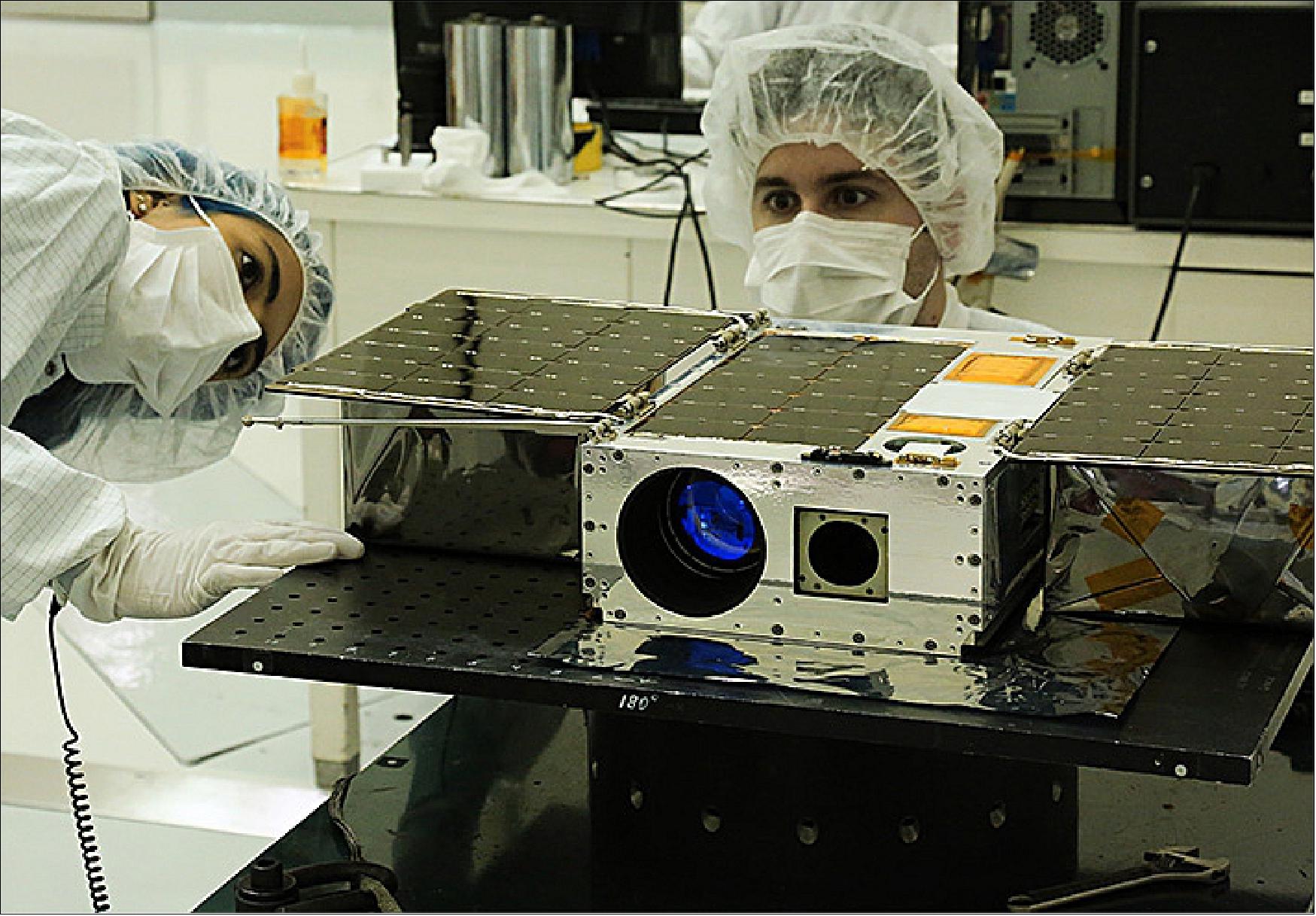 Figure 1: Electrical Test Engineer Esha Murty (left) and Integration and Test Lead Cody Colley (right) prepare the ASTERIA spacecraft for mass properties measurements in April 2017 prior to spacecraft delivery (image credit: NASA/JPL)