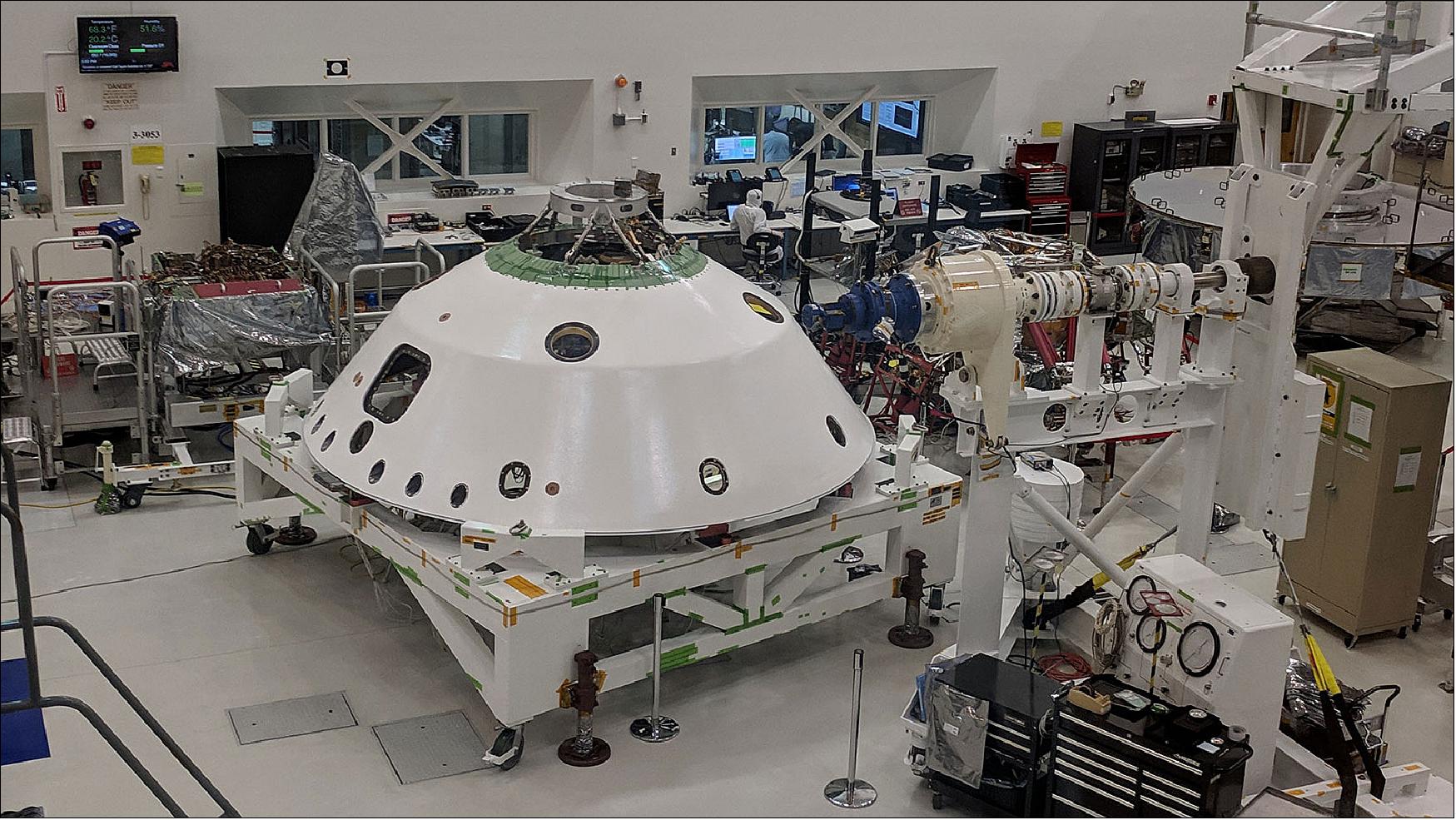 Figure 14: Lonely Vigil: With the backshell that will help protect the Mars 2020 rover during its descent into the Martian atmosphere visible in the foreground, a technician on the project monitors the progress of Systems Test 1 (image credit: NASA/JPL-Caltech)