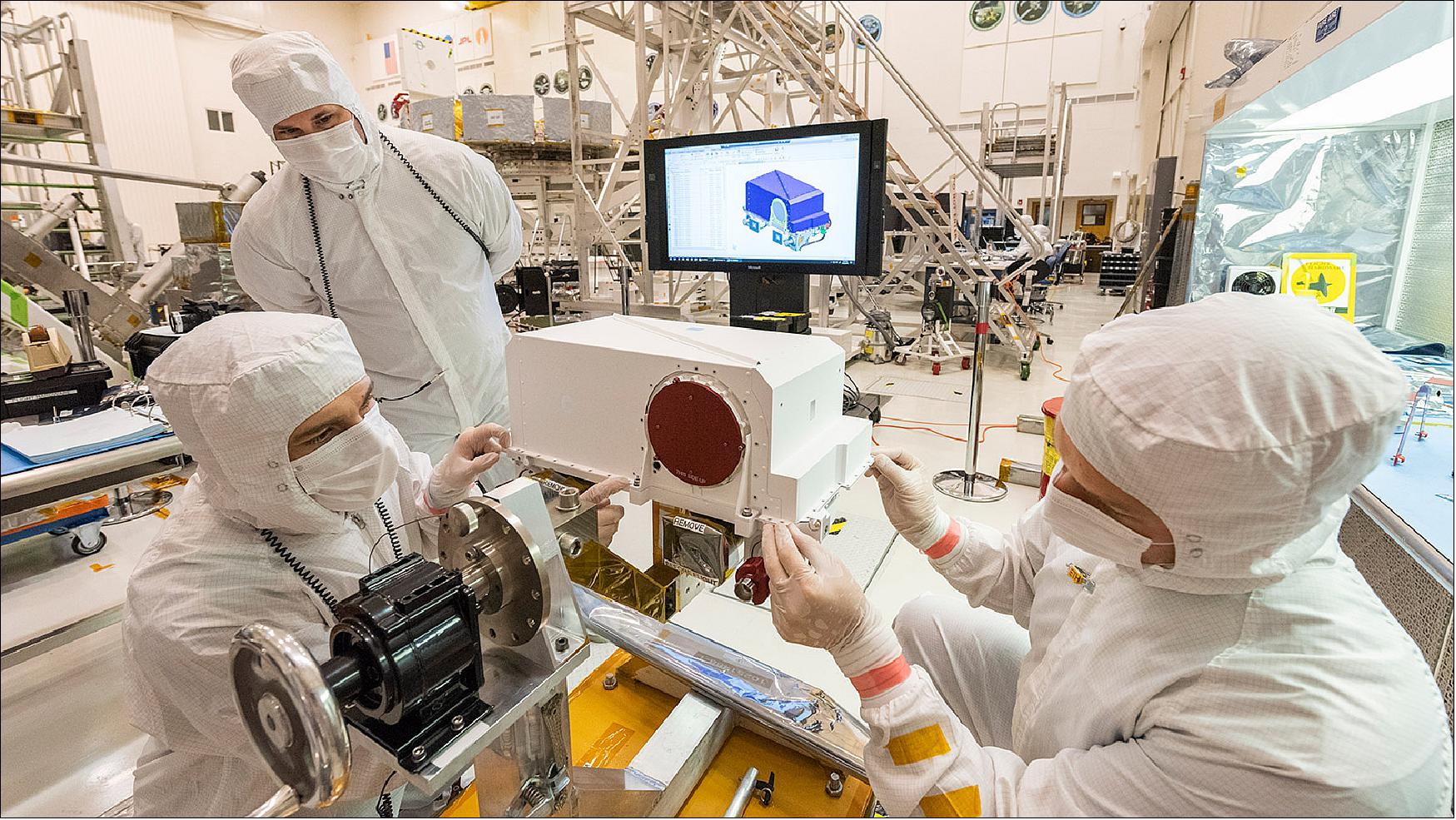 Figure 10: In this picture - taken on May 23, 2019, in the Spacecraft Assembly Facility's High Bay 1 clean room at the JPL in Pasadena, California - engineers re-install the cover to the RSM head after integration of two Mastcam-Z high-definition cameras. Visible below the red lens cover is the left Mastcam-Z camera (with the "Remove Before Flight" labels); support equipment blocks the right Mastcam-Z from view. The RSM and its twin cameras will be installed on the rover's deck the week of June 3, 2019 (image credit: NASA/JPL, Caltech)