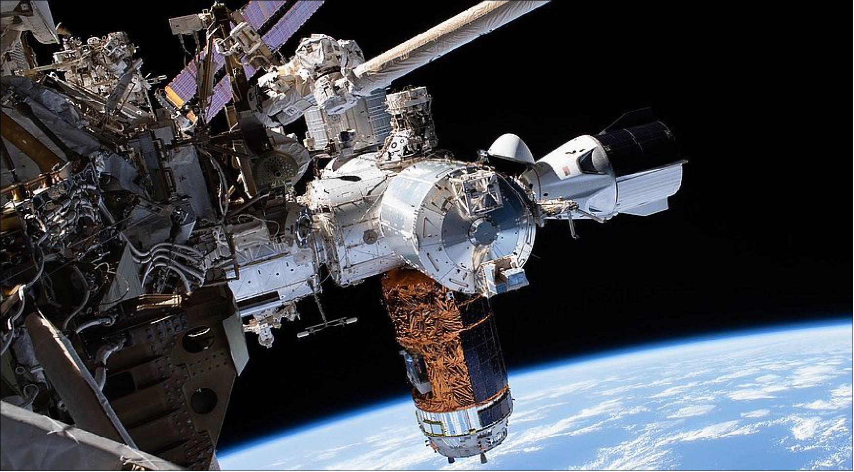Figure 6: The SpaceX Crew Dragon spacecraft (right) docked to the space station as seen during a recent spacewalk. The spacecraft will undock from the station and return to Earth in early August. The structure in the bottom center of the image is the HTV-9 vehicle of JAXA (image credit: NASA)