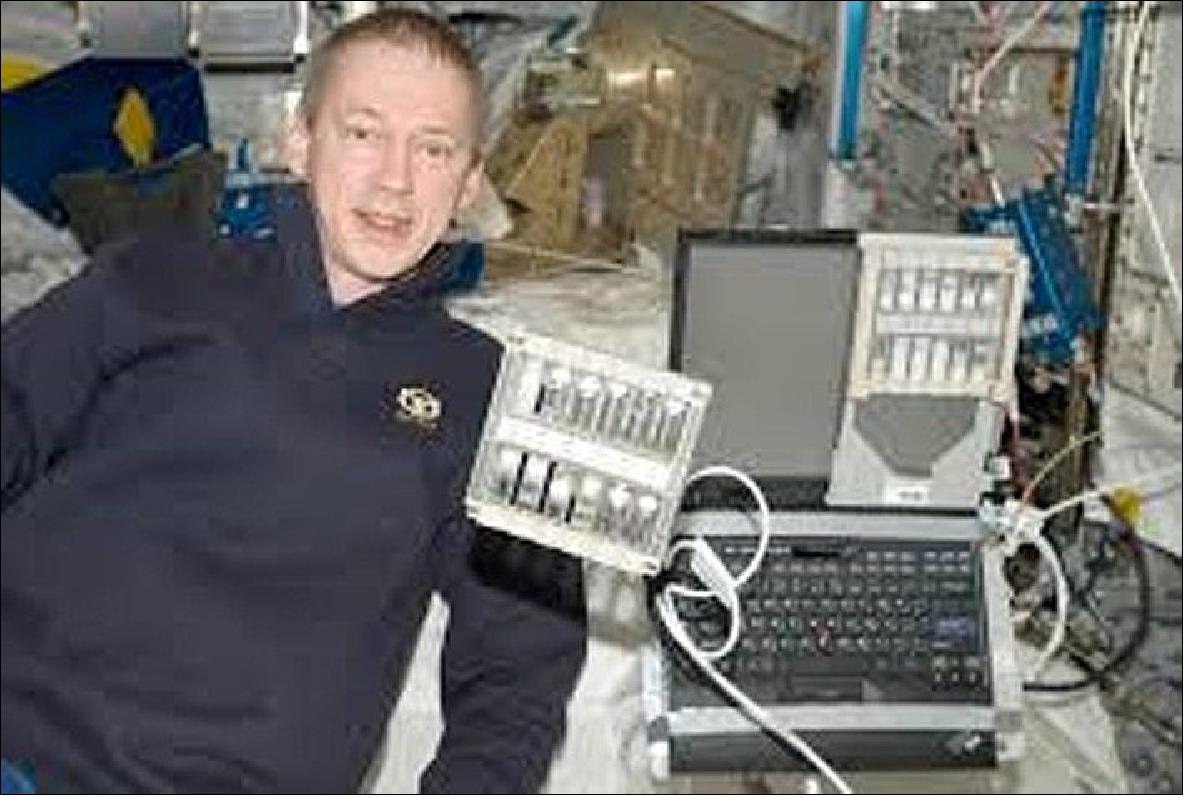 Figure 7: Astronaut Frank de Winne on the ISS. A rack containing the foam samples is free floating in the center of the picture. A second rack is placed in front of a computer screen for backlight illumination during video recording (photo credit: ESA)