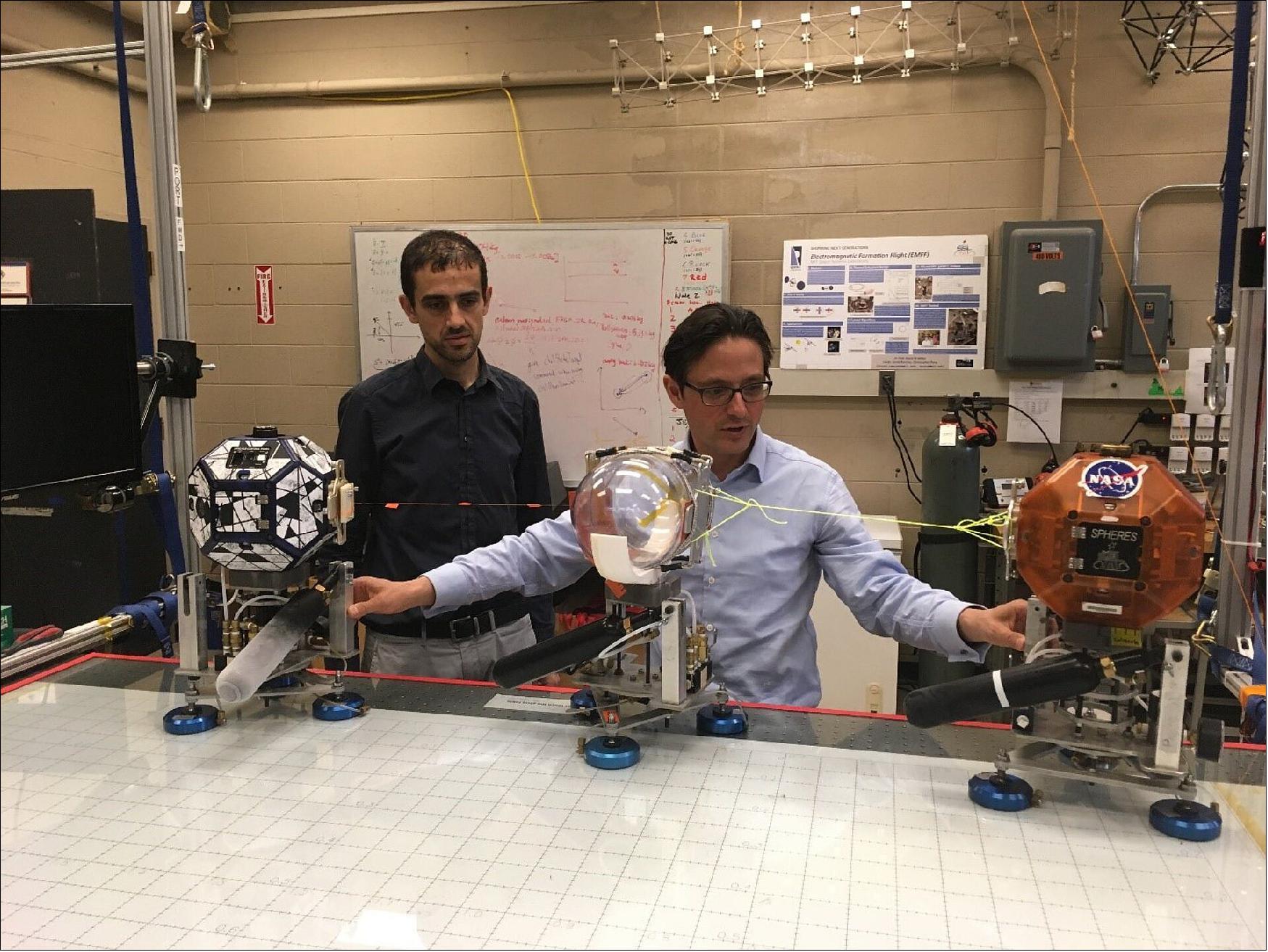 Figure 23: Spheres ISS experiment. Dr. Danilo Roascio (Massachusetts Institute of Technology, MIT) and Dr. Philipp Behruzi (ArianeGroup) at MIT labs conducting a first experimental set up of the NASA SPHERES Tether Slosh (photo credit: MIT)