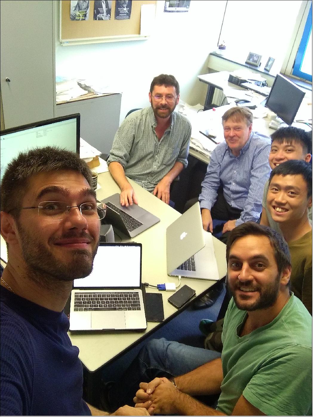 Figure 34: "The six happiest people in the world" on August 17, 2017. Salvatore Vitale (left) snapped this photo moments after first seeing the LLO scan. The tell-tale trace of gravitational waves generated by merging neutron stars was clearly visible. Clockwise from top: Chris van den Broeck, Jo van den Brand, Peter Pang, Ka Wa Tsang, and Michalis Agathos (image credit: Salvo Vitale)