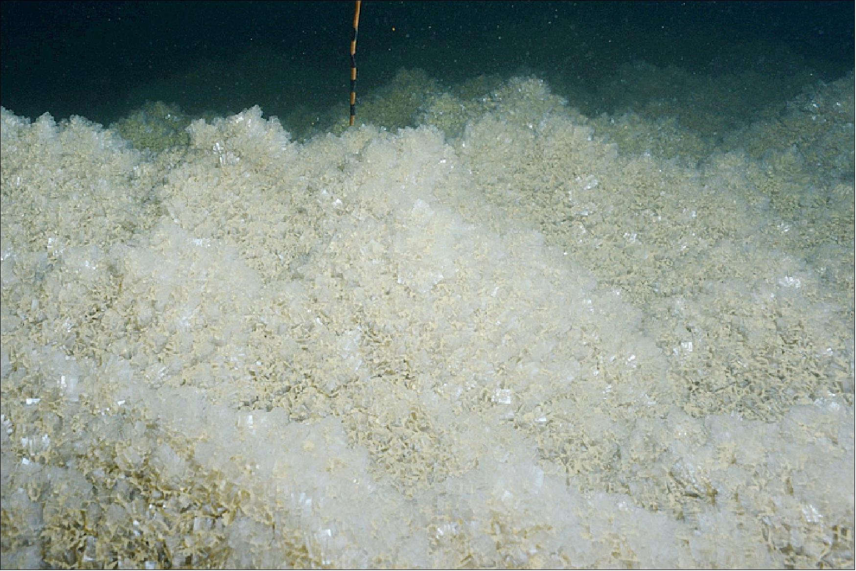 Figure 58: As the water level drops, the lake becomes saltier, particularly near the surface. Scientists from the Dead Sea Observatory have discovered that salt has been precipitating out of the water and coating the bottom of the lake. They found the amount of salt on the lakebed (photograph) depended on the season and the various salt densities throughout the lake. The salt layer has been growing about 10 cm thicker every year for the past four decades, showing seasonal alternations of the layers’ properties (image credit: Photograph provided by the Dead Sea Observatory, Geological Survey of Israel. Story by Kasha Patel)
