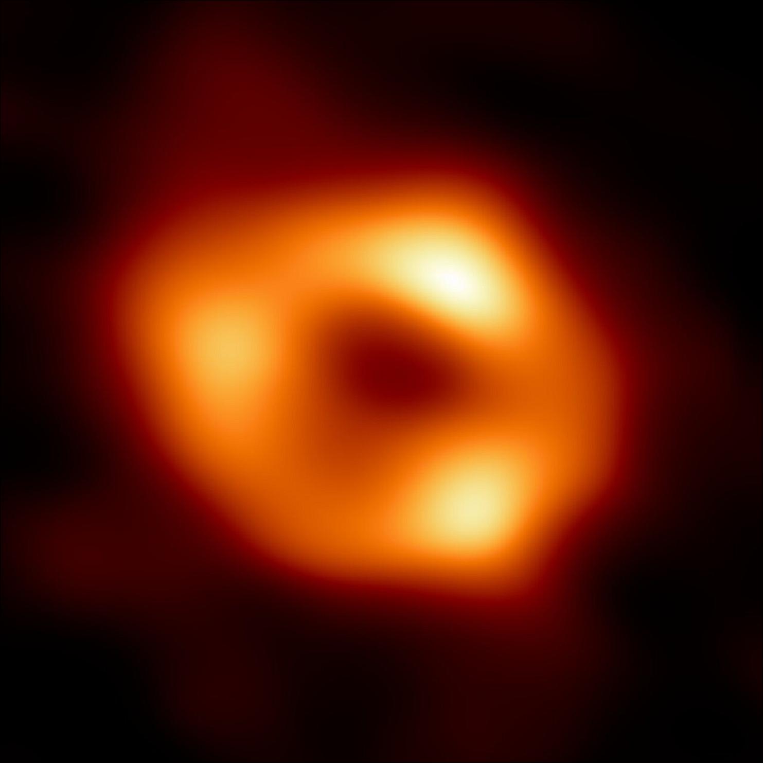 Figure 21: This is the first image of Sgr A*, the supermassive black hole at the centre of our galaxy. It’s the first direct visual evidence of the presence of this black hole. It was captured by the Event Horizon Telescope (EHT), an array which linked together eight existing radio observatories across the planet to form a single “Earth-sized” virtual telescope. The telescope is named after the event horizon, the boundary of the black hole beyond which no light can escape. - Although we cannot see the event horizon itself, because it cannot emit light, glowing gas orbiting around the black hole reveals a telltale signature: a dark central region (called a shadow) surrounded by a bright ring-like structure. The new view captures light bent by the powerful gravity of the black hole, which is four million times more massive than our Sun. The image of the Sgr A* black hole is an average of the different images the EHT Collaboration has extracted from its 2017 observations. - In addition to other facilities, the EHT network of radio observatories that made this image possible includes the Atacama Large Millimeter/submillimeter Array (ALMA) and the Atacama Pathfinder EXperiment (APEX) in the Atacama Desert in Chile, co-owned and co-operated by ESO is a partner on behalf of its member states in Europe (image credit: EHT Collaboration)