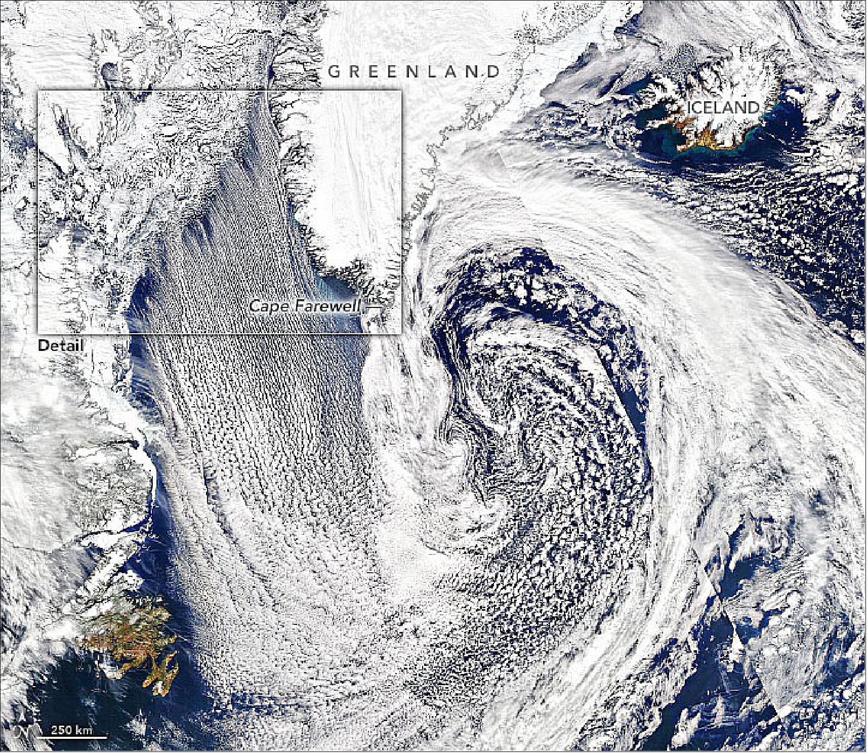 Figure 26: The wide view reveals even more compelling cloud patterns. Notice that the cloud streets are adjacent to an area of vortices off the southeast coast of Greenland. According to Gunilla Svensson, a meteorologist at Stockholm University, those clouds were likely related to a narrow band of high winds known as a “tip jet.” A tip jet is thought to be caused by winds that accelerate as they are forced to go around the steep topography of Cape Farewell (image credit: NASA Earth Observatory)