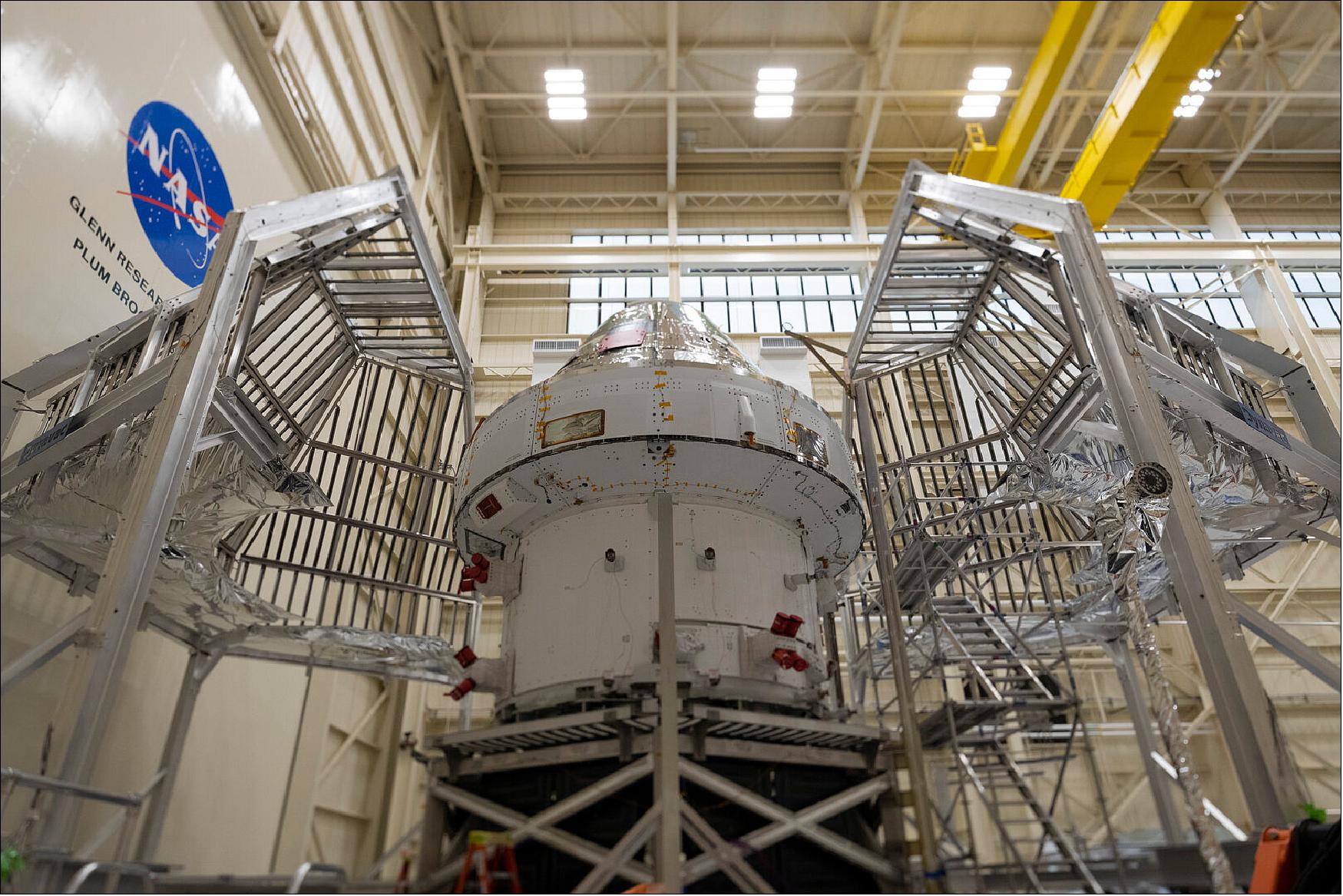 Figure 49: The Orion spacecraft with European Service Module at NASA’s Plum Brook Station. The first Orion will fly farther from Earth on the Artemis I mission than any human-rated vehicle has ever flown before – but first it will undergo testing to ensure the spacecraft withstands the extremes of spaceflight. In this figure, Orion is being placed in a cage, called the Thermal Enclosure Structure (TES), that will radiate infrared heat during the tests inside the vacuum chamber (image credit: ESA, S. Corvaja)