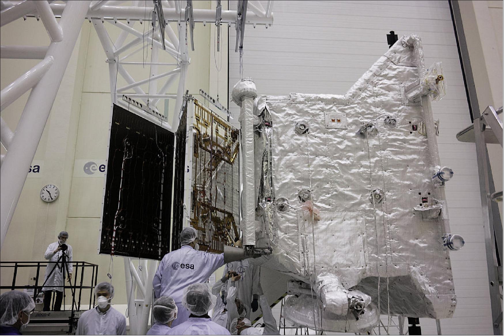 Figure 148: ESA's MPO (Mercury Planetary Orbiter) first saw the 7.5 m long three-panel solar wing being attached, and then unfurled. This was the first time the array had been deployed while attached to the orbiter. The panels were held from above to simulate the weightlessness of space (image credit: ESA)
