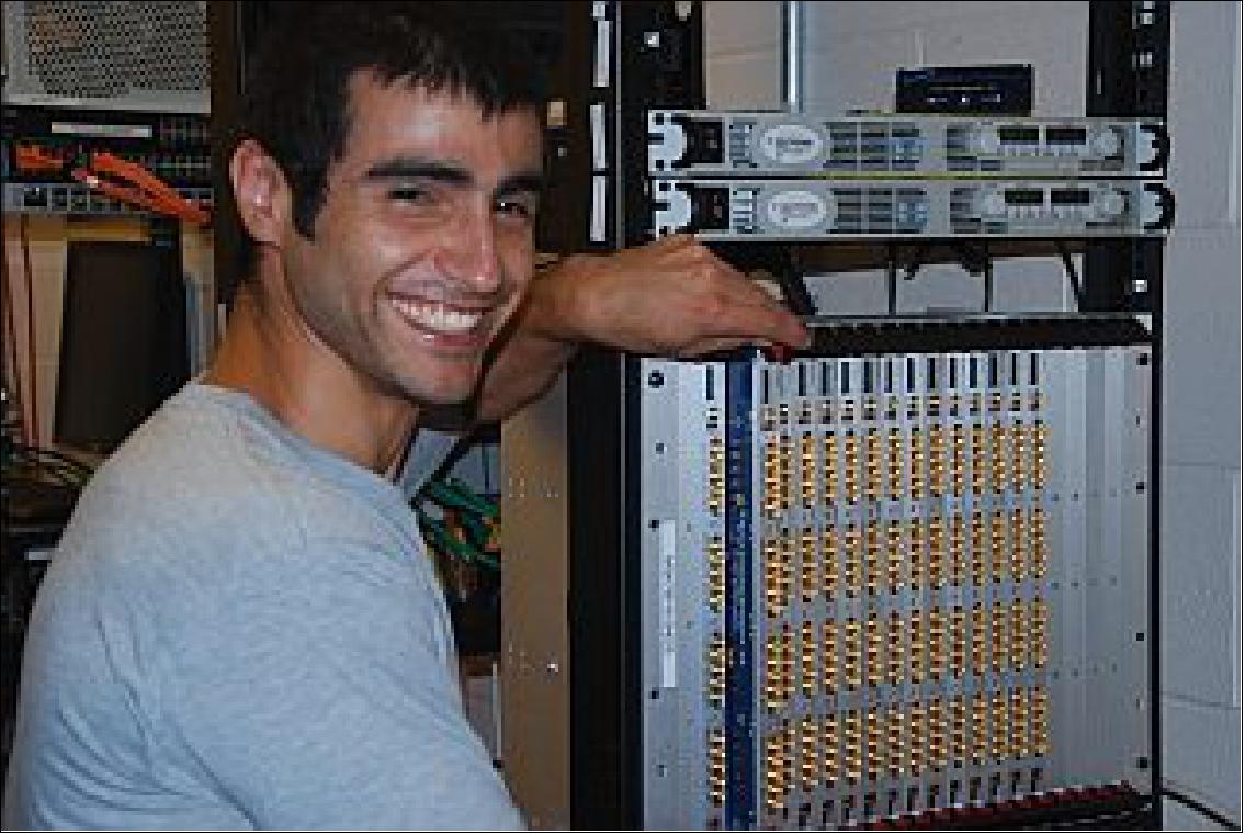 Figure 2: CHIME graduate student researcher Juan Mena with the custom electronics from the CHIME correlator (photo: Keith Vanderlinde)