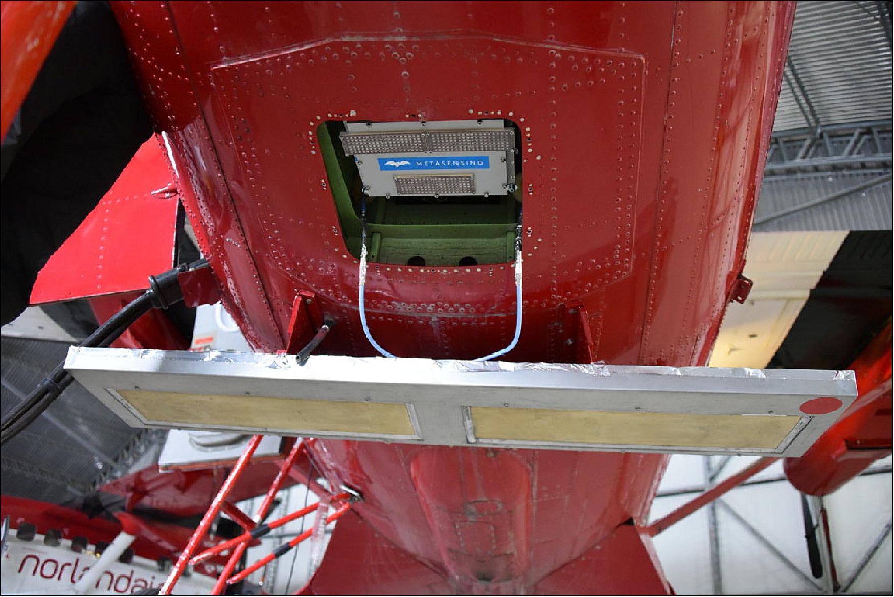 Figure 54: Two antennas under the fuselage of the Twin Otter plane can be seen in this photograph. The bigger antenna (lower part of the image) belongs to the AS IRAS instrument and measures at Ku-band, the same frequency as that of CryoSat-2. The smaller antenna within the fuselage hole was built by MetaSensing BV and uses the higher-frequency Ka-band. Future dual-frequency satellites, which exist only on the drawing board at the moment, can be simulated from the air by combining the frequencies. The concept is being tested as part of an experiment campaign in the Arctic (image credit: ESA) 62)