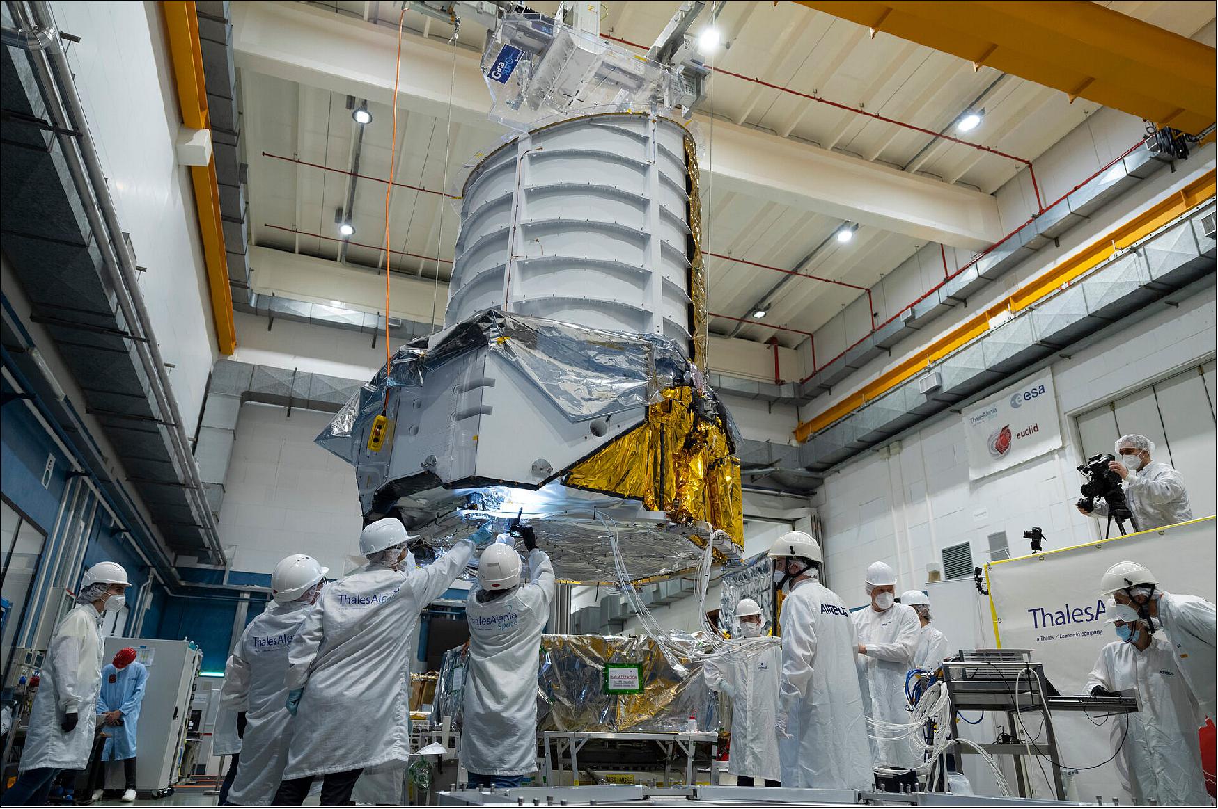 Figure 19: On 24 March 2022, ESA came one step closer to unveiling the mysteries of the dark Universe, following the coming together of two key parts of the Euclid spacecraft – the instrument-carrying payload module and the supporting service module. This image shows the 800 kg payload module being lifted by a crane, just before it was lowered onto the service module. Euclid’s instruments were integrated onto the payload module at the end of 2020. During 2021, the complete module successfully passed intensive testing under simulated space conditions to check that the telescope and instruments work as expected (image credit: ESA - S. Corvaja)