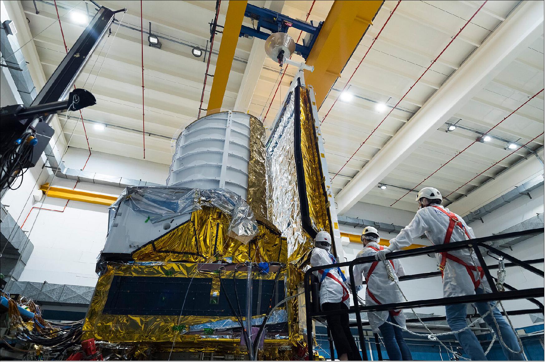 Figure 18: In this image, taken on 23 May 2022, engineers at Thales Alenia Space in Turin are attaching a combined sunshield and solar panel module to the main body of ESA’s Euclid spacecraft. The module has two functions: whilst the solar panels will provide the spacecraft with power, the sunshield will shade the instrument-carrying payload module from the Sun’s intense radiation (image credit: ESA, S. Corvaja)