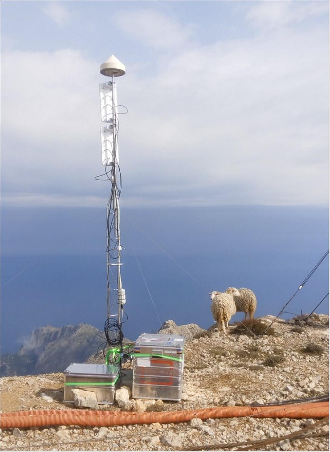 Figure 32: An experimental satellite navigation receiver station high atop Spain's Mallorca island has opened up a novel view of the ever-changing face of the sea. By picking up satnav signals from the far horizon as they bounce off ocean waves, the receivers are able to measure sea surface height down to a scale of centimeters. A pair of satnav receivers was positioned in a near-horizontal orientation, 1400 m above sea level atop Mallorca's highest peak, 4 km from the coast, seen here with grazing sheep (image credit: Institute for Space Studies of Catalonia)