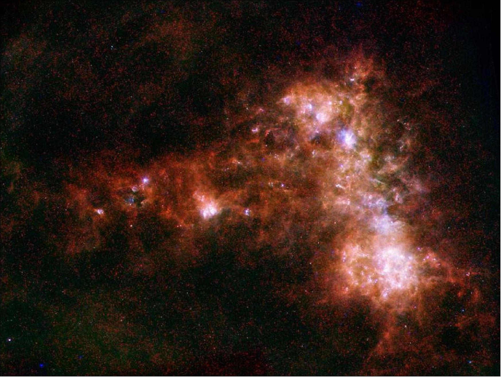 Figure 53: In combined data from Herschel and Spitzer, the irregular distribution of dust in the Small Magellanic Cloud becomes clear. A stream of dust extends to the left in this image, known as the galaxy's "wing," and a bar of star formation appears on the right (image credit: ESA, NASA/JPL-Caltech, STScI)