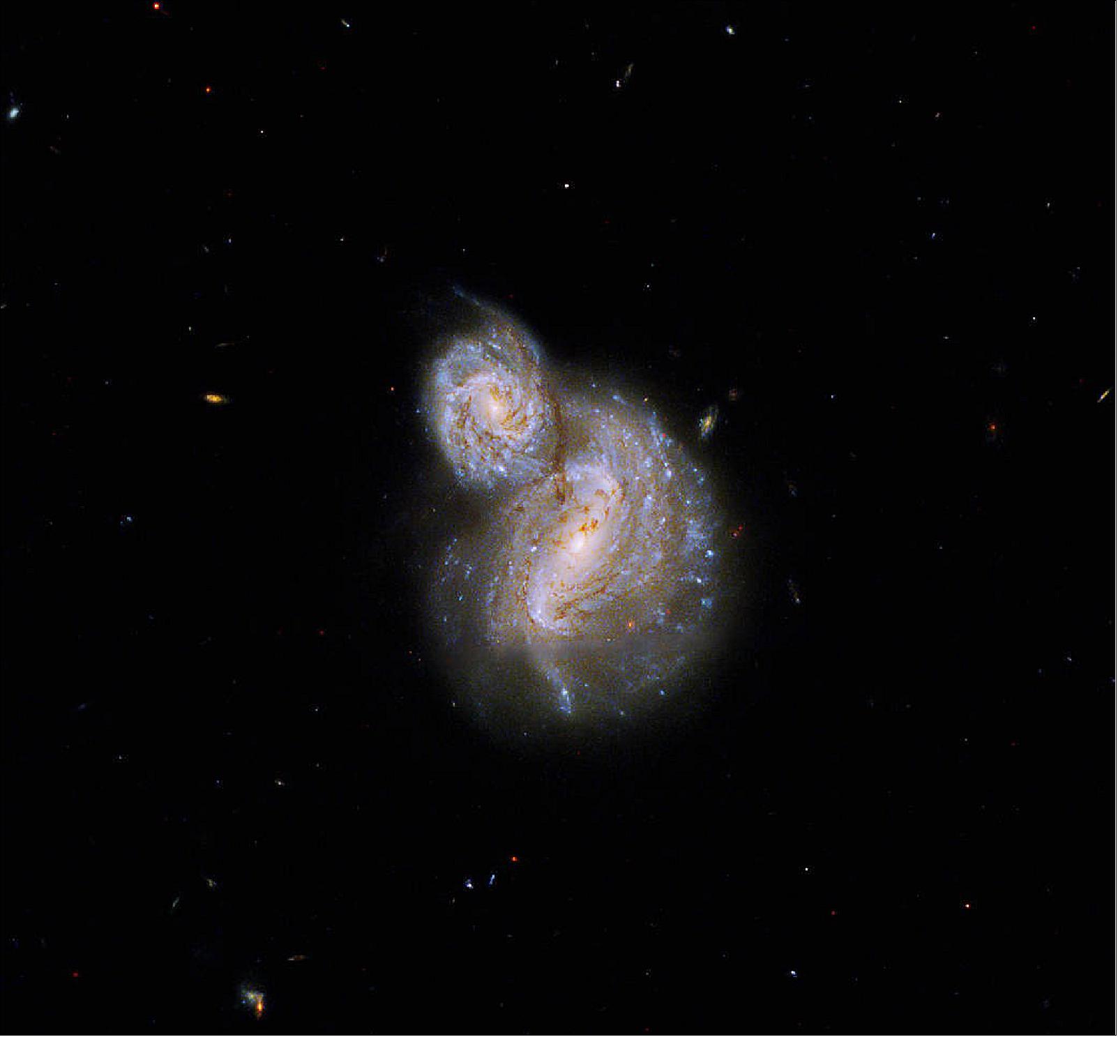 Figure 34: The image uses data collected during Hubble observations designed to study the role of dust in shaping the energy distributions of low mass disk galaxies. The Hubble observations looked at six pairs of galaxies where one was in front of the other. The broad range of light that Hubble’s Wide Field Camera 3 is sensitive to, along with its resolution, allowed the researchers to map the foreground galaxy’s dust disk in fine detail across ultra-violet, visible, and infrared light. Because IC 4271 is a Type II Seyfert Galaxy, visible and infrared wavelengths of light dominate the image. The colors in this image are primarily visible light, while the color violet represents ultraviolet light and red represents near infrared light [image credit: NASA, ESA, and B. Holwerda (University of Louisville Research Foundation, Inc.); Image processing: G. Kober (NASA Goddard/Catholic University of America)]
