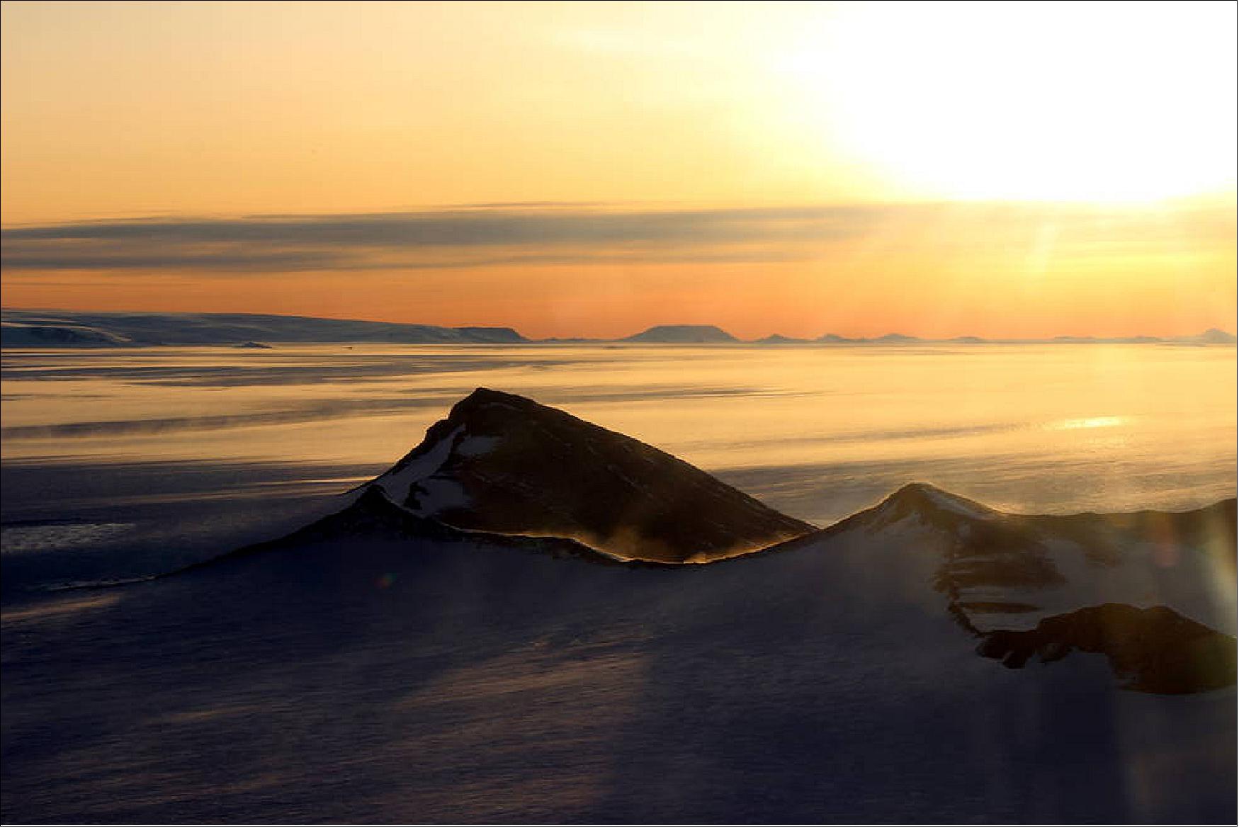 Figure 72: The Shackleton Range in Antarctica at sunset with snow blowing off the ridges, photographed during an Operation IceBridge flight on 10 October 2018 (image credits: NASA/Michael Studinger)