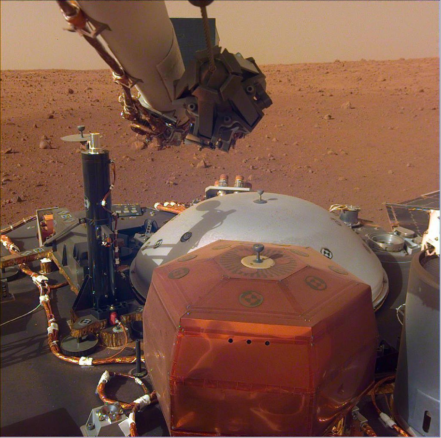 Figure 52: This image from InSight's robotic-arm mounted Instrument Deployment Camera shows the instruments on the spacecraft's deck, with the Martian surface of Elysium Planitia in the background (image credit: NASA/JPL-Caltech)