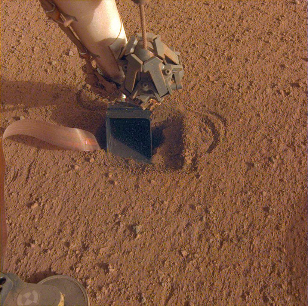 Figure 30: The movement of sand grains in the scoop on the end of NASA InSight's robotic arm suggests that the spacecraft's self-hammering "mole," which is in the soil beneath the scoop, had begun tapping the bottom of the scoop while hammering on June 20, 2020 (image credit: NASA/JPL-Caltech)