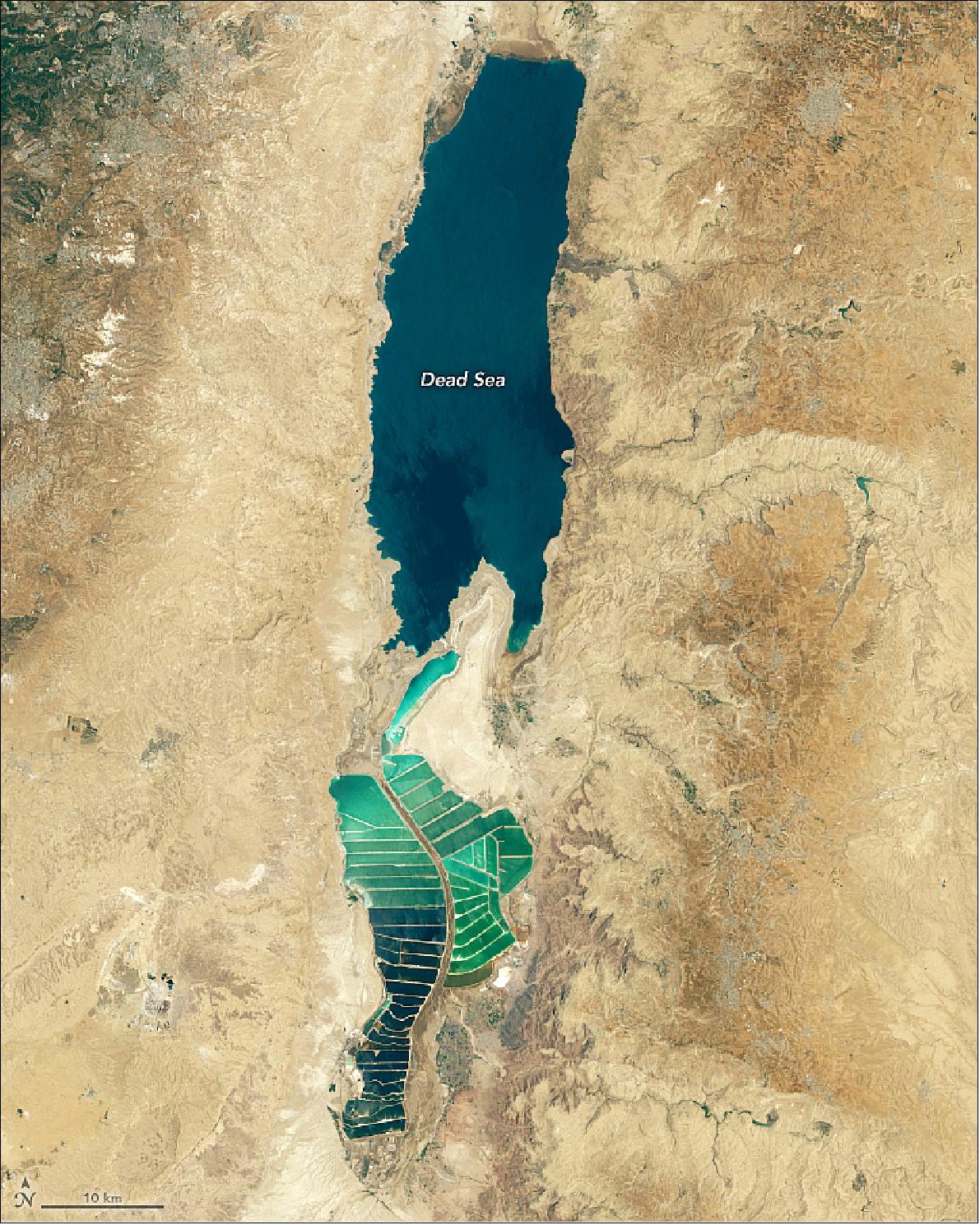 Figure 57: As water levels drop in the Dead Sea, salt is piling up on the lakebed. This image shows the Dead Sea and the Jordan Rift Valley on July 21 2019, as observed by the Operational Land Imager on the Landsat 8 satellite. The green rectangles on the south end of the lake are salt evaporation ponds, which are used to extract sodium chloride and potassium salts for the manufacturing of polyvinyl chloride (PVC) and other chemicals (image credit: NASA Earth Observatory images by Lauren Dauphin, using Landsat data from the U.S. Geological Survey. Story by Kasha Patel)