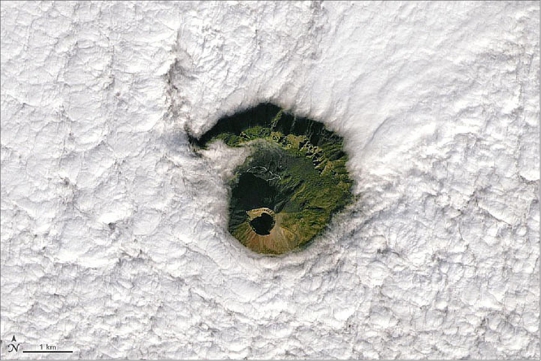 Figure 92: In this natural-color image, acquired on January 2, 2022, by the Operational Land Imager (OLI) on Landsat-8, the cone of Mount Vesuvius appears through a break in the clouds. The ridge surrounding the cone is a remnant of the collapsed caldera of an older volcano, Mount Somma, from which the cone of Vesuvius emerged (image credit: NASA Earth Observatory image by Joshua Stevens, using Landsat data from the U.S. Geological Survey. Story by Sara E. Pratt)