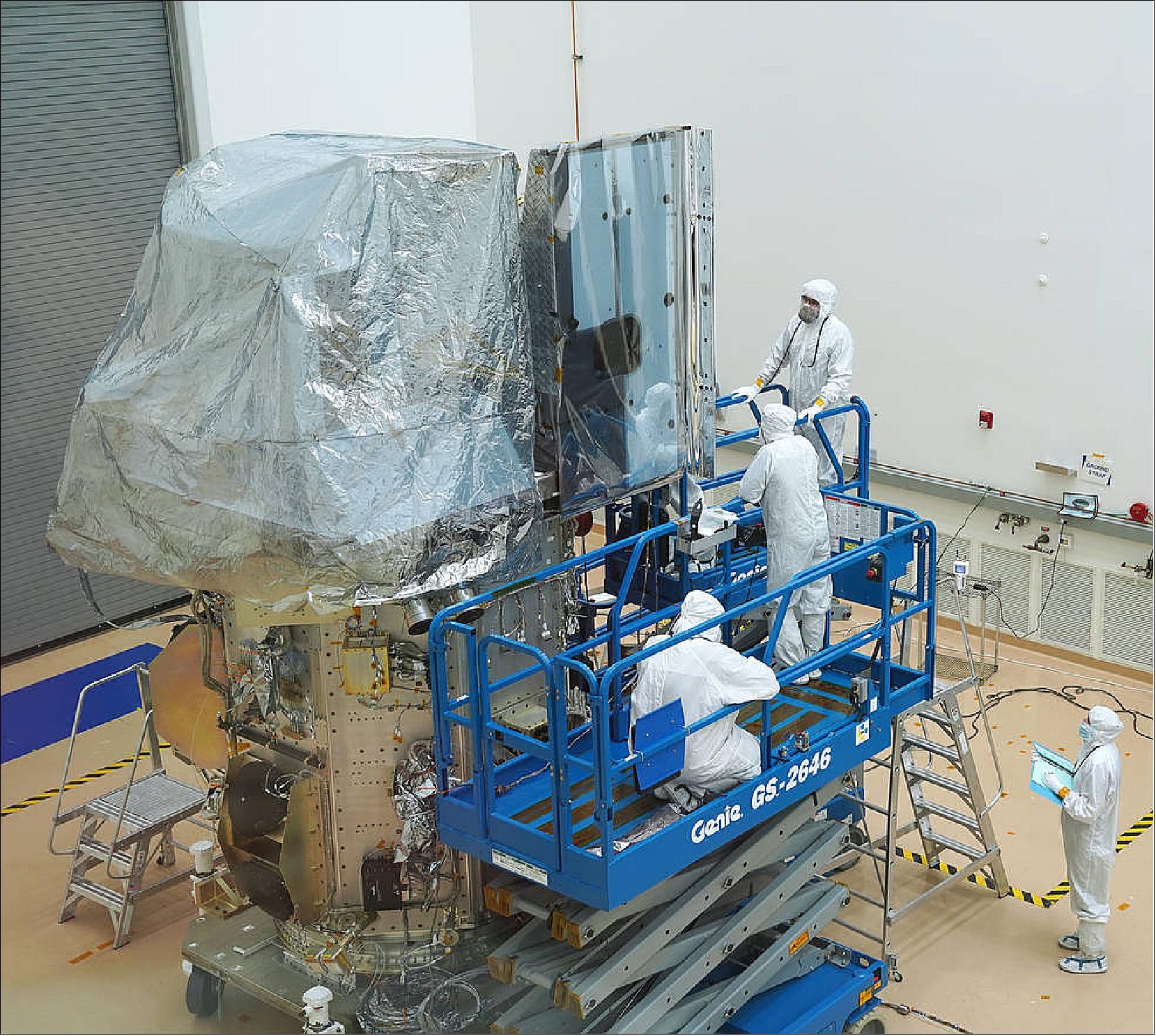 Figure 5: Engineers work on the newly integrated Landsat 9 satellite in a cleanroom at the Northrop Grumman facility in Gilbert, Arizona. In December, the team attached Landsat 9’s two instruments: OLI-2 (left) and TIRS-2 (right) to the spacecraft bus at the bottom of the image. The two instruments are covered to protect them from contaminants ( image credit: Northrop Grumman)