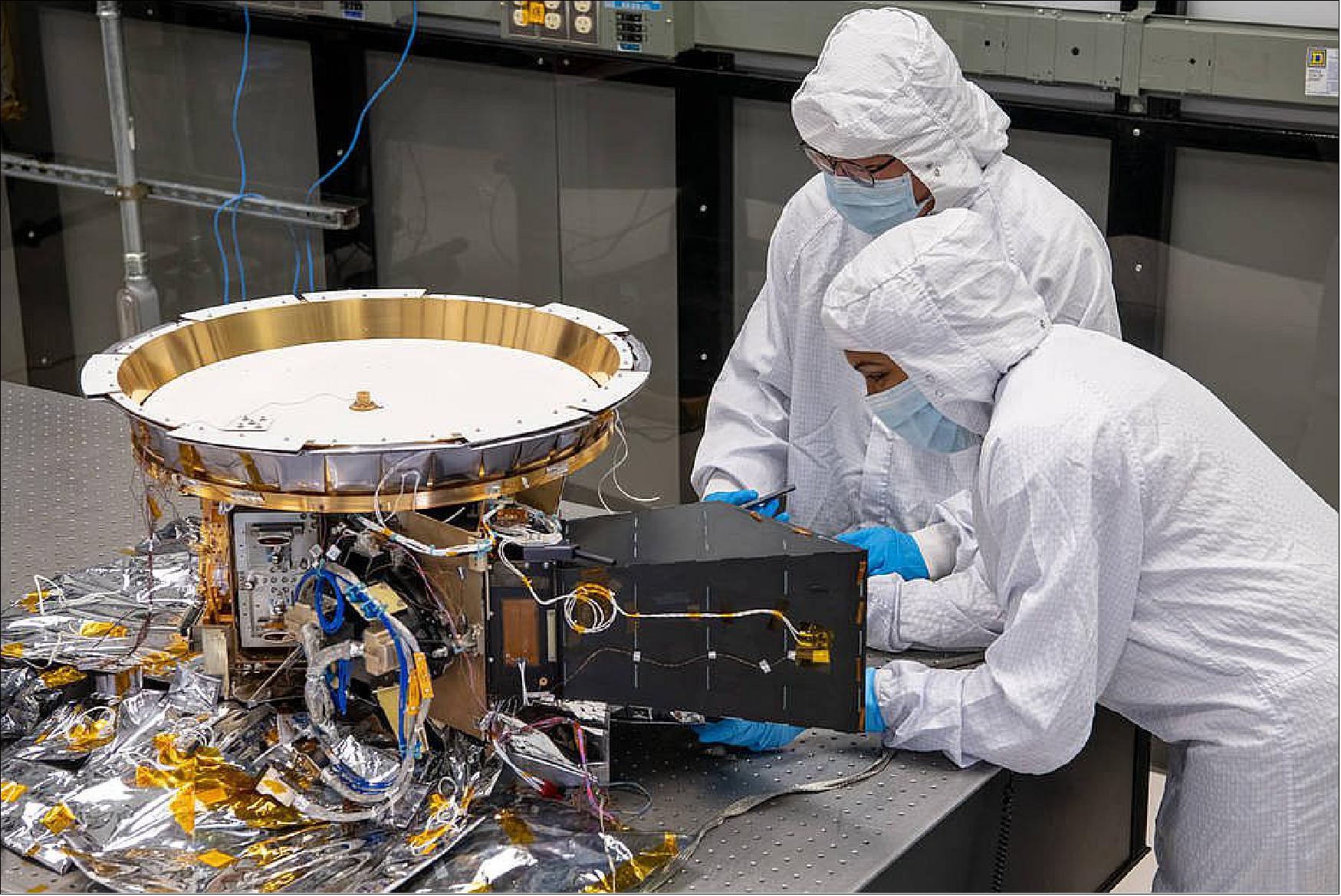 Figure 16: Two engineers work on L'Ralph, the most complicated instrument that will fly on the Lucy mission to Jupiter's Trojan asteroids. It is actually two instruments in one. The Multispectral Visible Imaging Camera (MVIC), will take visible light color images. The Linear Etalon Imaging Spectral Array (LEISA), will collect infrared spectra (image credits: NASA/Goddard/Barbara Lambert/Desiree Stover)