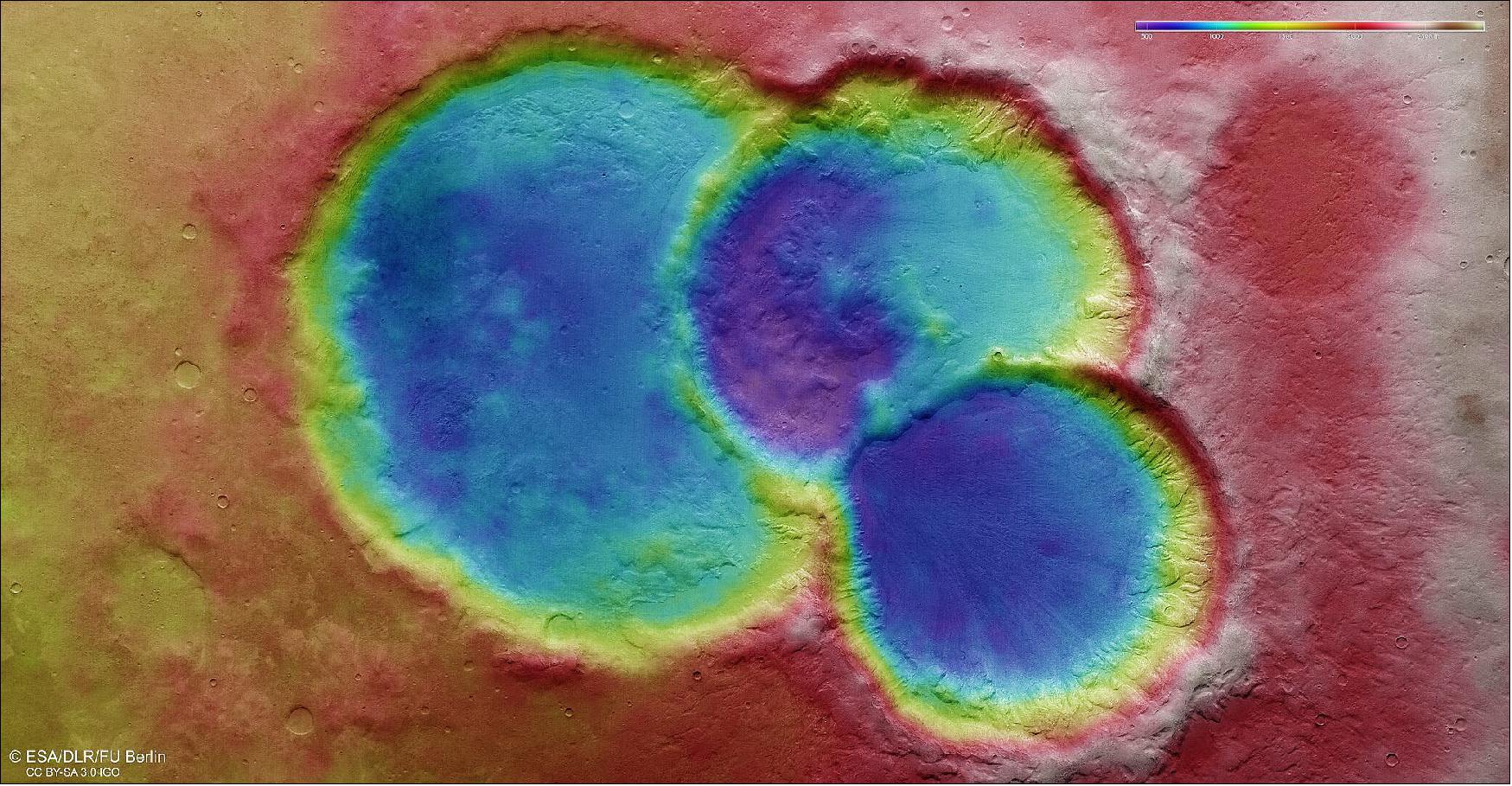 Figure 72: Topographic view of triple crater on Mars. This color-coded topographic image shows a triple crater in the ancient martian highlands, based on data gathered by the Mars Express High Resolution Stereo Camera (HRSC) during orbit 20982 (6 August 2020). This view is based on a digital terrain model (DTM) of the region, from which the topography of the landscape can be derived; lower parts of the surface are shown in blues and purples, while higher altitude regions show up in whites, yellows and reds, as indicated on the scale to the top right. North is to the right (image credit: ESA/DLR/FU Berlin, CC BY-SA 3.0 IGO)