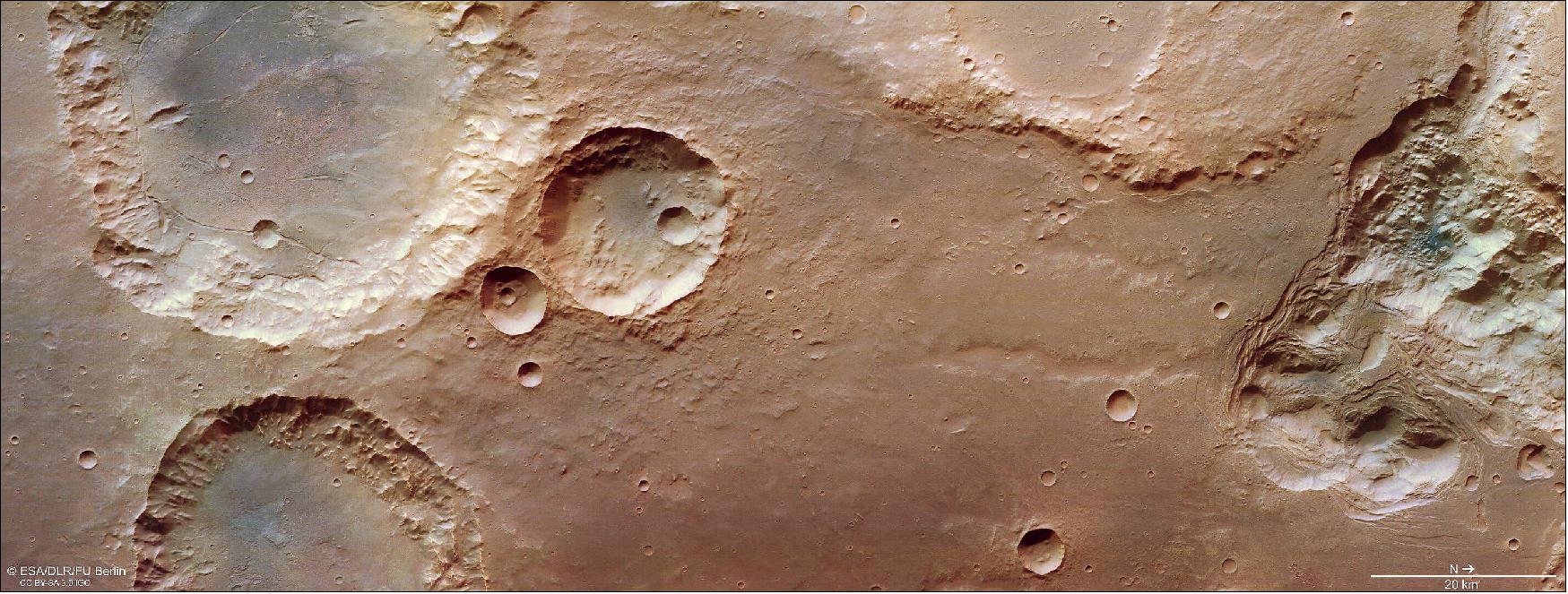 Figure 65: This image from ESA’s Mars Express shows craters, valleys and chaotic terrain in Mars’ Pyrrhae Regio. This image comprises data gathered by ESA’s Mars Express using its High Resolution Stereo Camera (HRSC) on 3 August 2020 (orbit 20972). The ground resolution is approximately 16 m/pixel and the images are centered at about 322°E/16°S. This image was created using data from the nadir and color channels of the HRSC. The nadir channel is aligned perpendicular to the surface of Mars, as if looking straight down at the surface. North is to the right (image credit: ESA/DLR/FU Berlin, CC BY-SA 3.0 IGO)