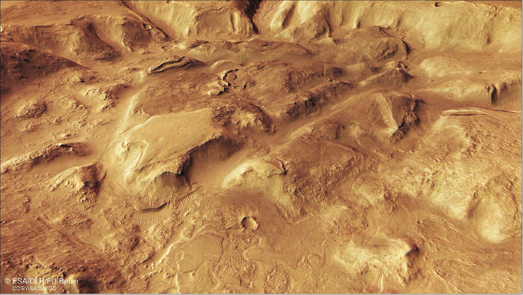 Figure 101: This image shows a region of Mars’ surface named Nilosyrtis Mensae. It comprises data gathered on 29 September 2019 during orbit 19908. The ground resolution is approximately 15 m/pixel and the images are centered at about 69ºE/31ºN. This image was created using data from the nadir and color channels of the HRSC. The nadir channel is aligned perpendicular to the surface of Mars, as if looking straight down at the surface. This perspective looks over the region from north to south (image credit: ESA/DLR/FU Berlin, CC BY-SA 3.0 IGO)