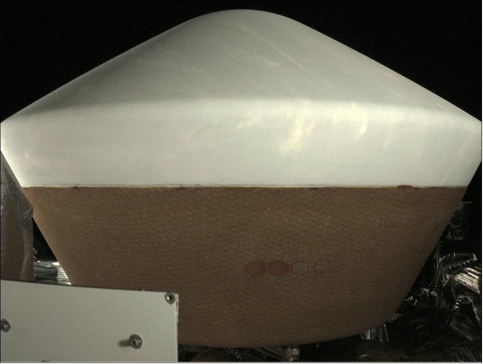 Figure 81: StowCam first light: Visible in the lower left hand side of the image is the radiator and sun shade for another instrument (SamCam) onboard the spacecraft. Featured prominently in the center of the image is the SRC (Sample Return Capsule), showing that our asteroid sample’s ride back to Earth in 2023 is in perfect condition. In the upper left and upper right portions of the image are views of deep space. No stars are visible due to the bright illumination provided by the sun (image credit: NASA)