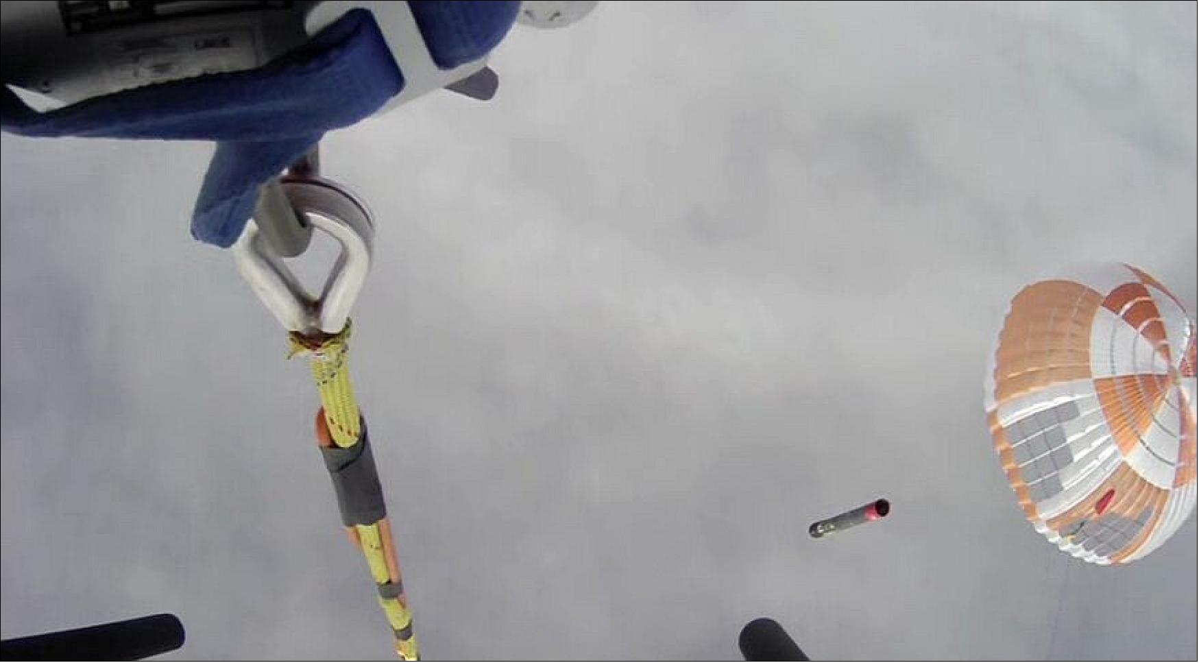 Figure 27: The Electron booster, descending under a parachute (right), as seen from the helicopter as it attempted to grapple the parachute. The helicopter released the booster moments later, though (image credit: Rocket Lab)