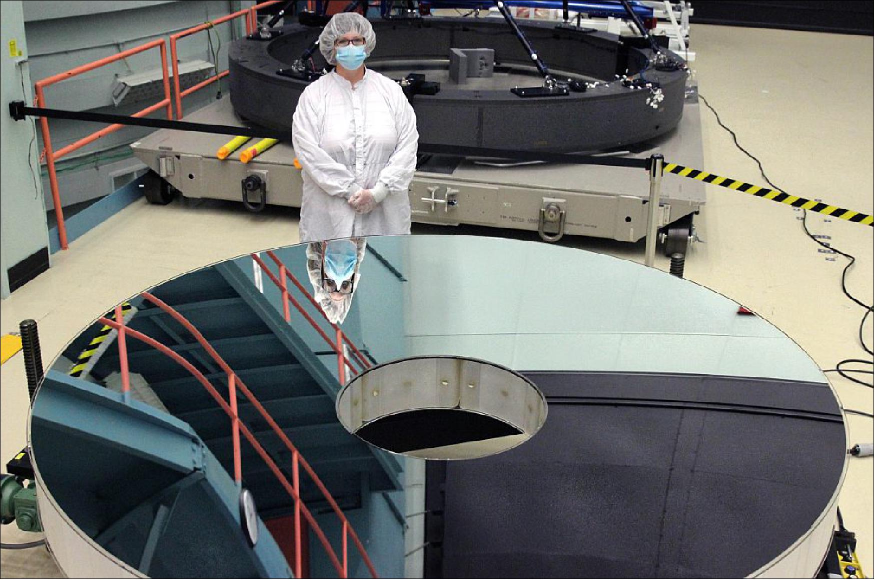 Figure 29: L3Harris' Bonnie Patterson stands with the completed primary mirror for the Nancy Grace Roman Space Telescope (photo credit: L3Harris)