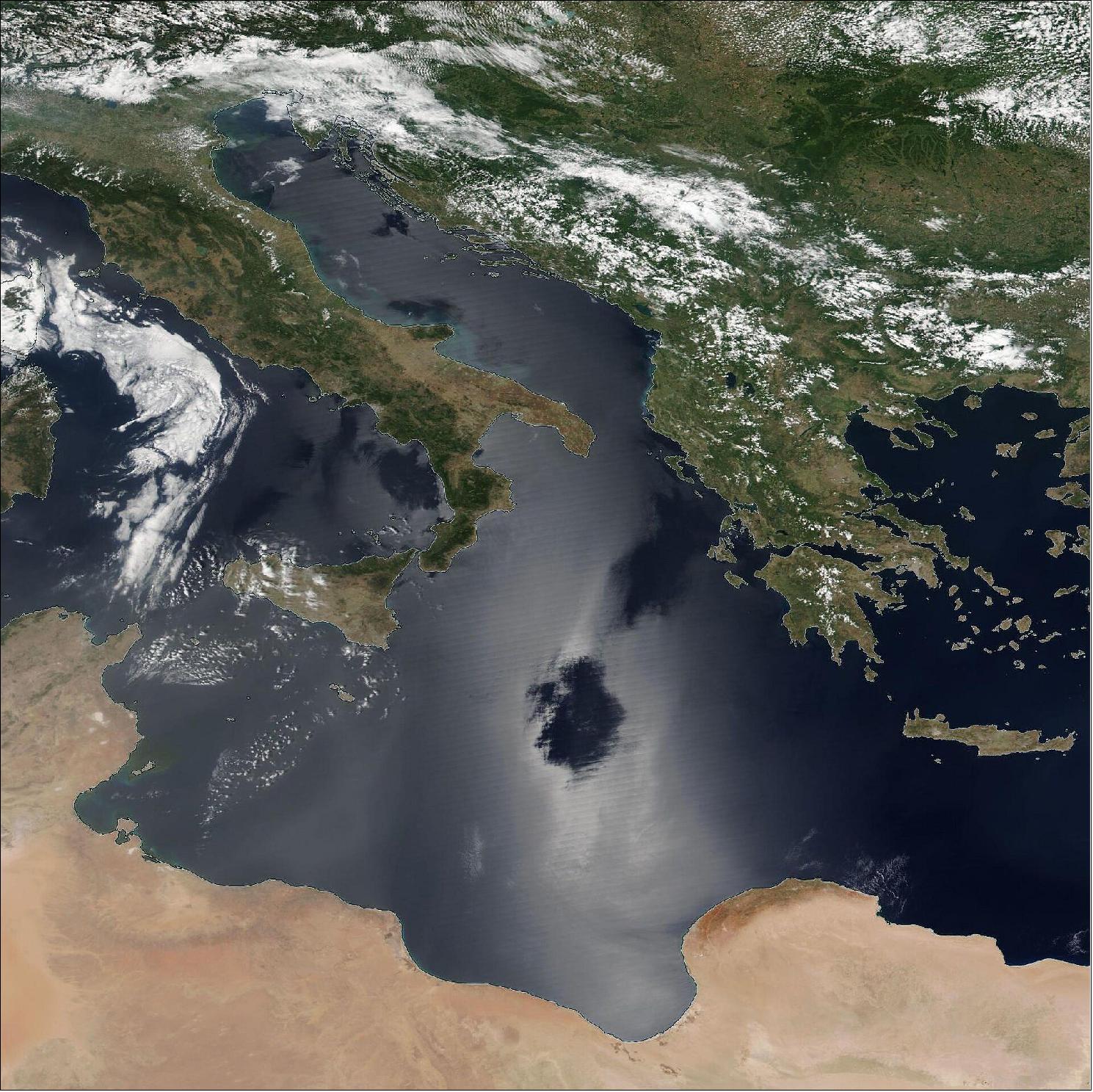 Figure 46: Sun glint pattern as seen in satellite data from the VIIRS instrument on the Naomi NPP satellite of NASA/NOAA on 2 July 2018. The dark spots in the middle of the sun glint are locations where the sea surface is nearly flat (lack of wind waves) and acts as a true mirror, in which case the sun glint effect disappears(image credit: NASA)