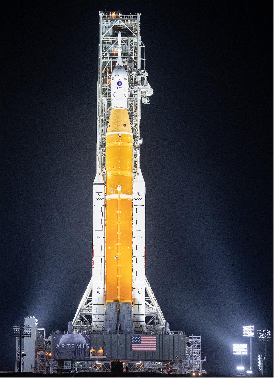 Figure 8: NASA’s Space Launch System (SLS) rocket with the Orion spacecraft aboard is seen illuminated by spotlights atop a mobile launcher at Launch Complex 39B, Friday, March 18, 2022, after being rolled out to the launch pad for the first time at NASA’s Kennedy Space Center in Florida. Ahead of NASA’s Artemis I flight test, the fully stacked and integrated SLS rocket and Orion spacecraft will undergo a wet dress rehearsal at Launch Complex 39B to verify systems and practice countdown procedures for the first launch (image credit: NASA)