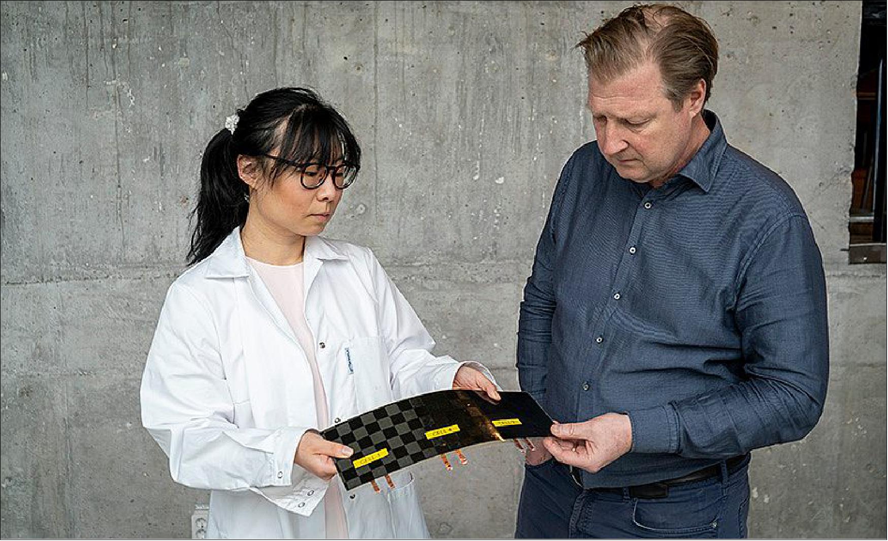 Figure 20: Doctor Johanna Xu with a newly manufactured structural battery cell in Chalmers’ composite lab, which she shows to Leif Asp. The cell consists of a carbon fibre electrode and a lithium iron phosphate electrode separated by a fibreglass fabric, all impregnated with a structural battery electrolyte for combined mechanical and electrical function (image credit: Marcus Folino)